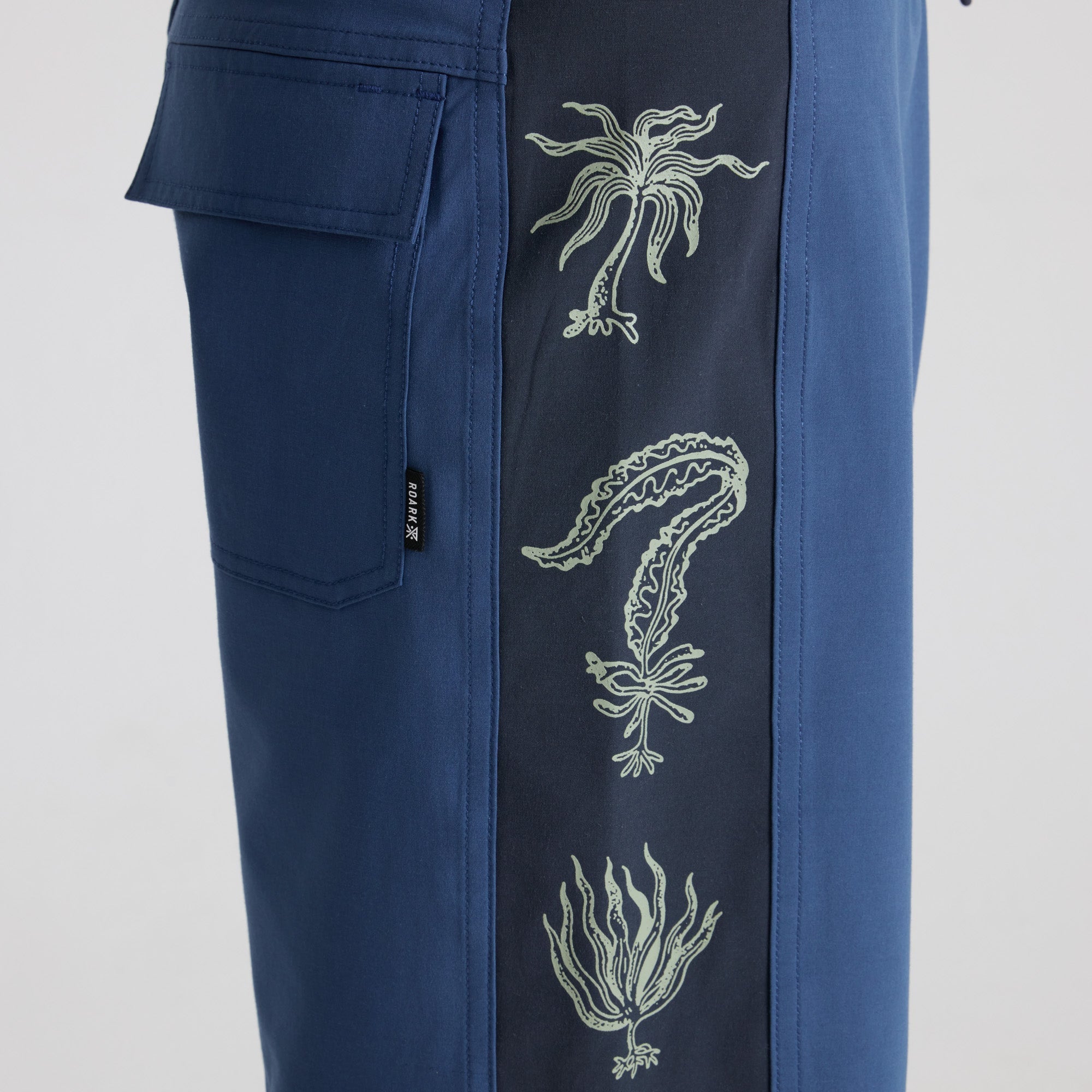 Dynamic blue active pants designed for adventure and travel by Roark, ideal for outdoor exploration and comfort.
