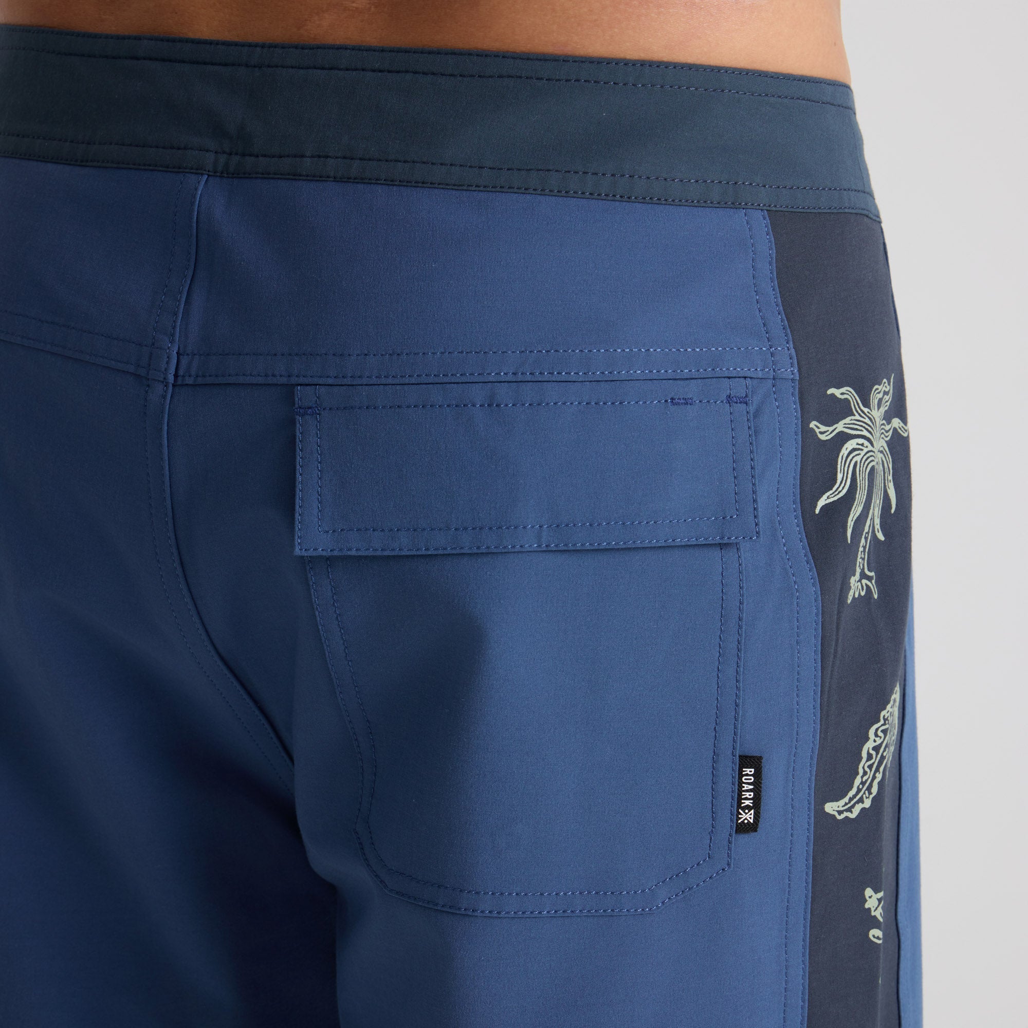 Versatile Roark men's boardshorts in action, ideal for travel and outdoor adventures, featuring a unique pattern perfect for any journey.