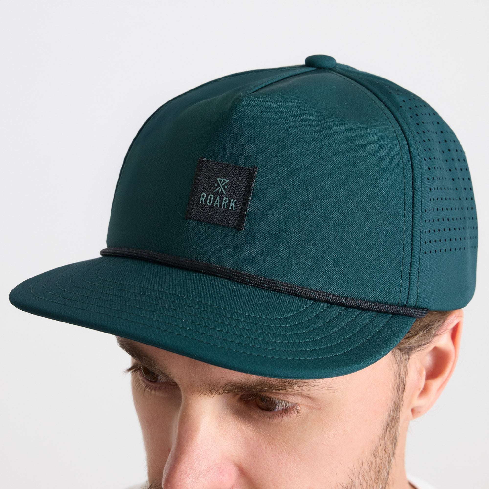 Cricket cap set against an adventurous backdrop, reflecting Roark's spirit of travel and outdoor exploration.