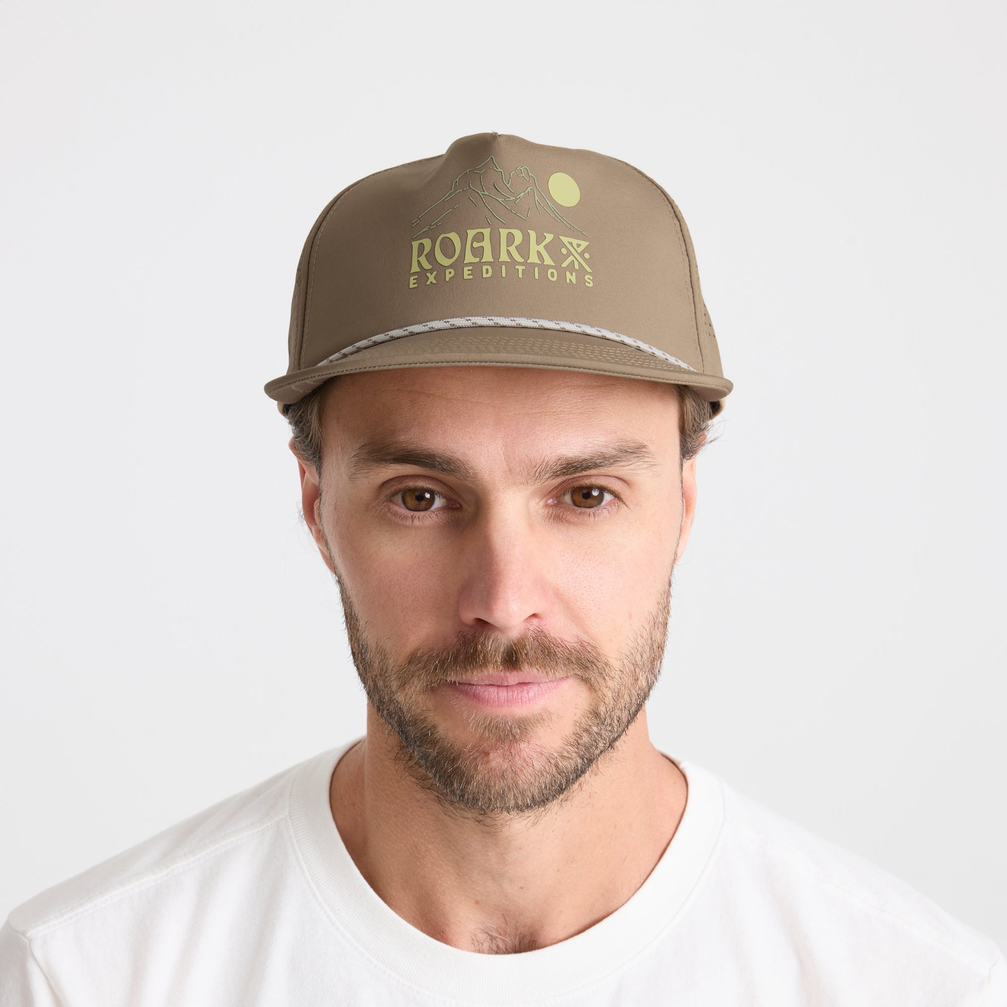 Man wearing a stylish cricket cap with subtle facial hair, embodying Roark's adventurous and outdoor spirit.