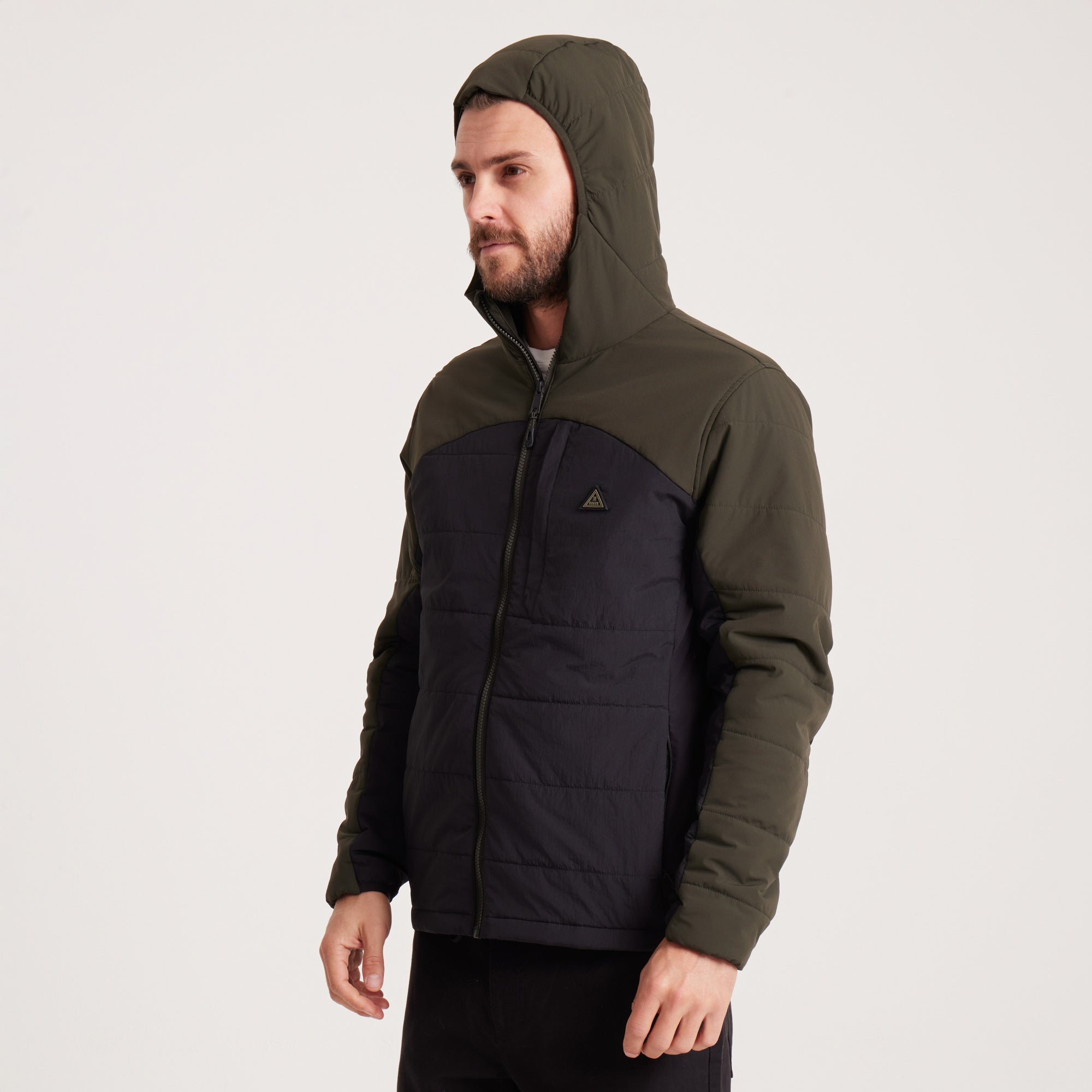 Side angle of a man wearing a green and black hooded jacket with focus on pockets, ideal for cold weather.