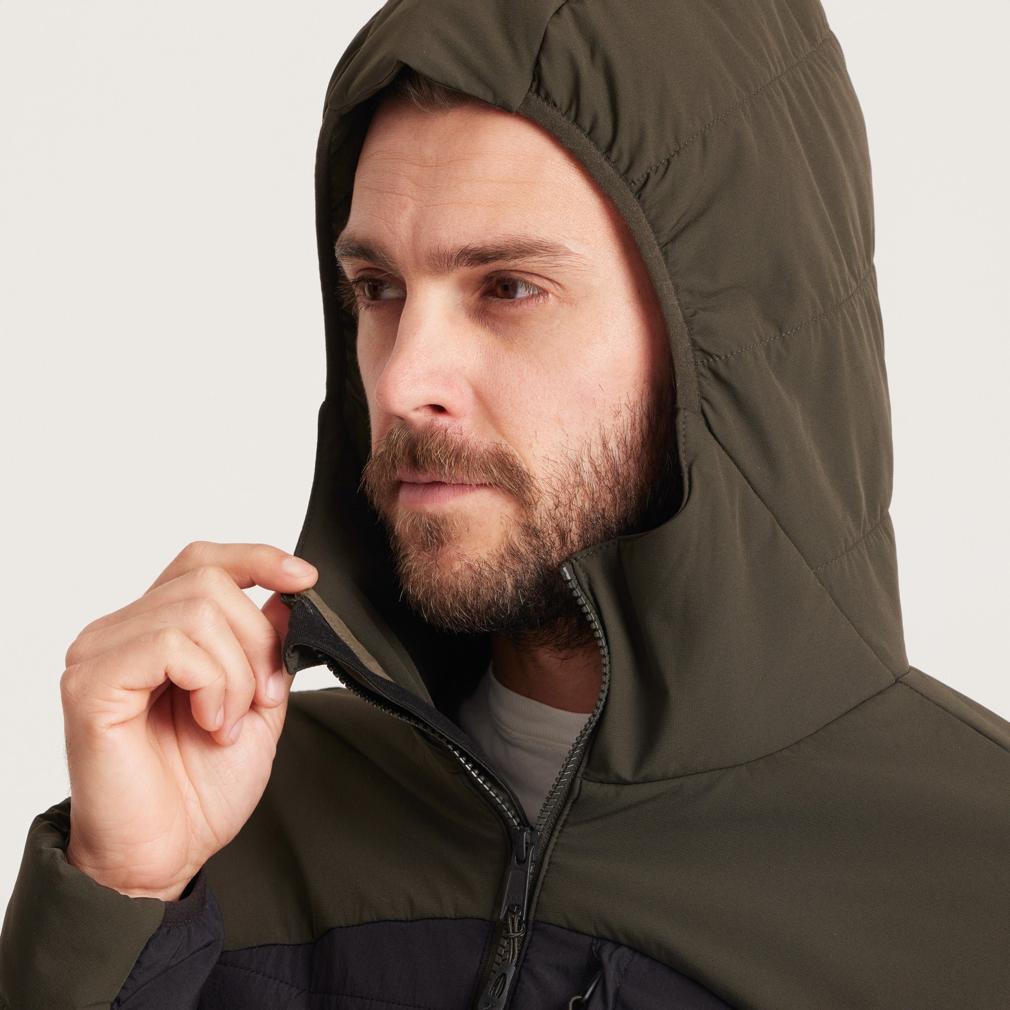 Zipper detail on a green and black hooded jacket, featuring smooth functionality and robust construction.
