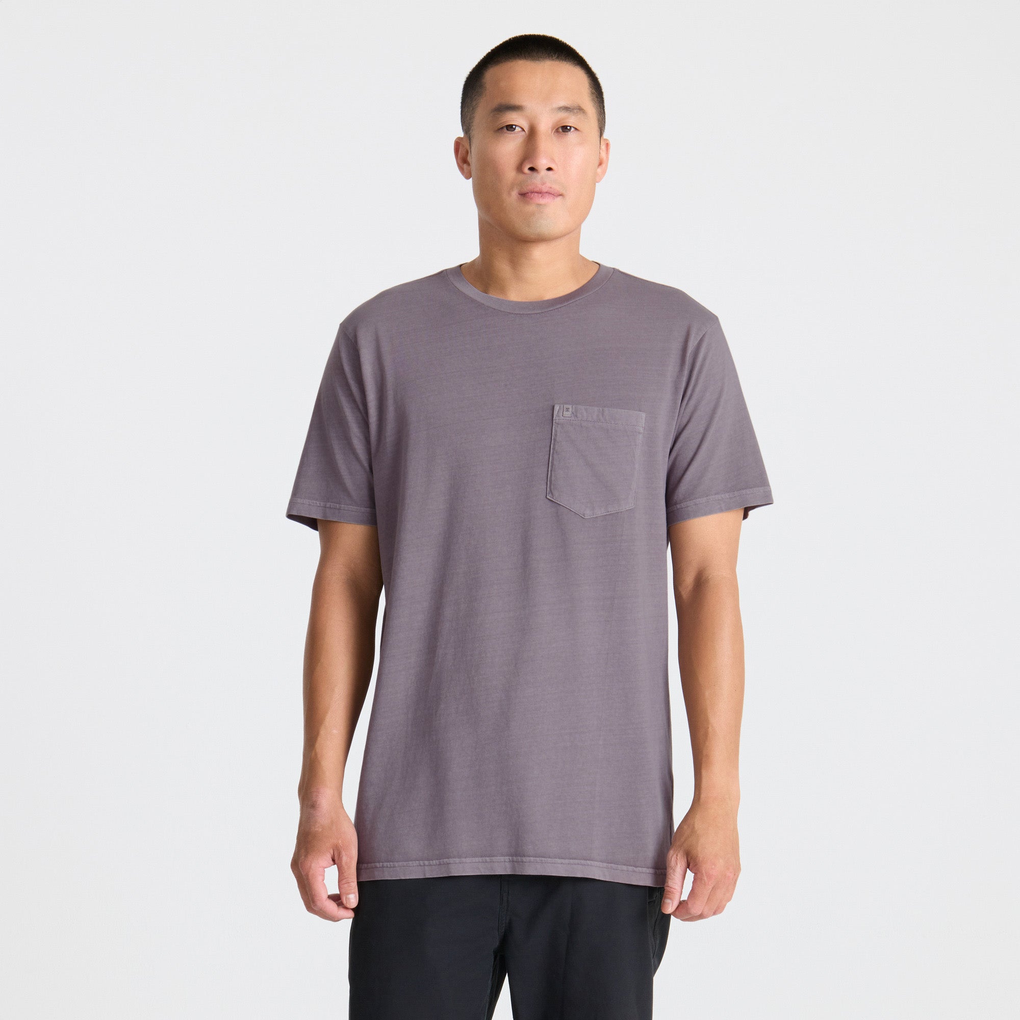 Man wearing a gray t-shirt with a pocket on a white background