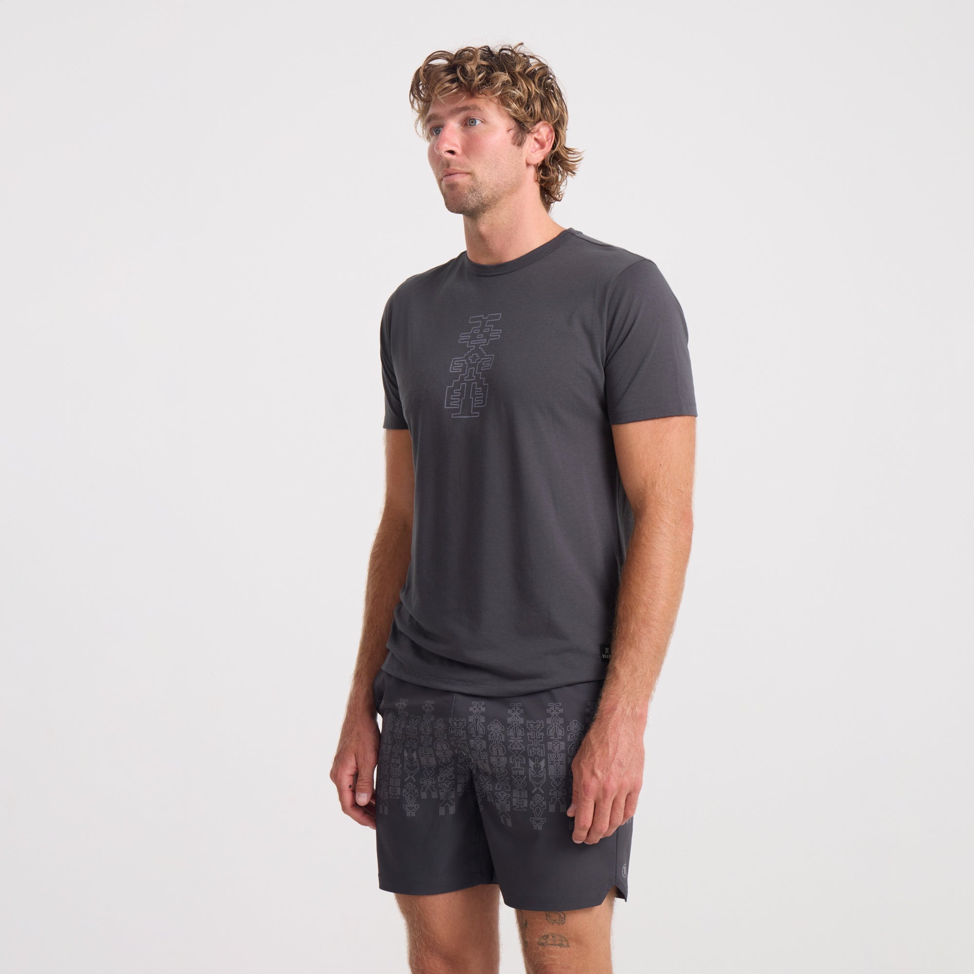 Adventure-ready grey active shirt paired with boardshorts by Roark, ideal for both travel and outdoor activities.