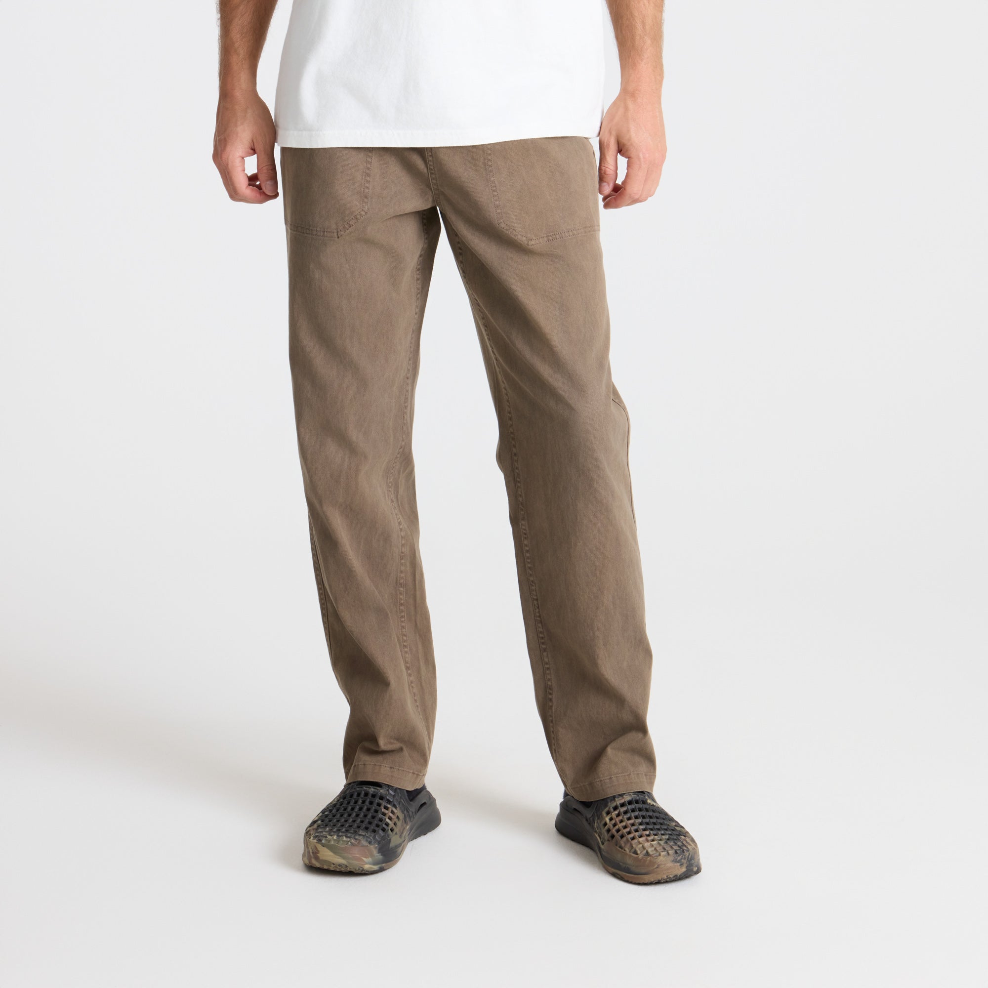 Versatile khaki cargo pants with multiple pockets, ideal for outdoor adventures and travel, displayed in a natural setting