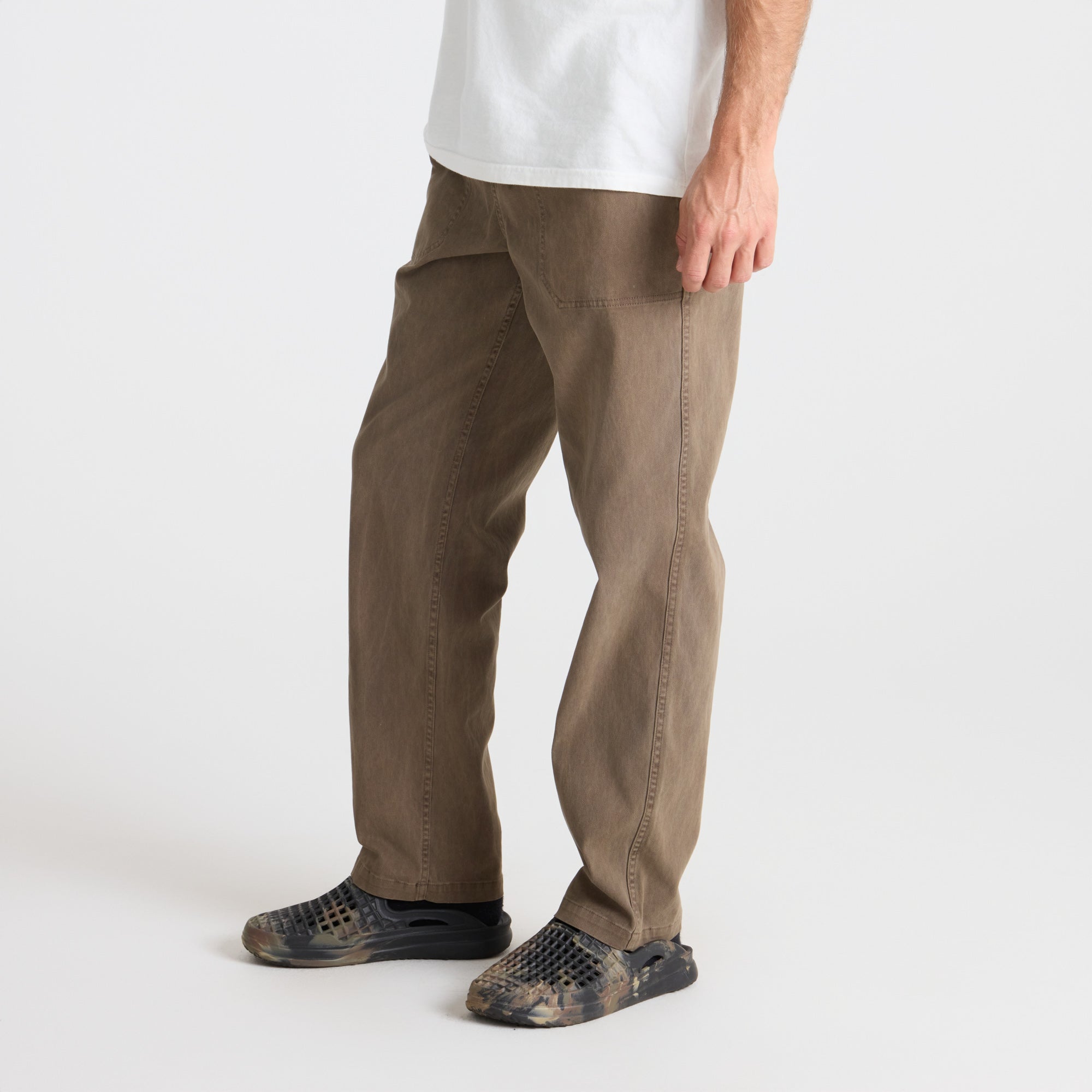 Roark adventurer wearing versatile khaki pants in a natural outdoor setting, perfect for travel and exploration.