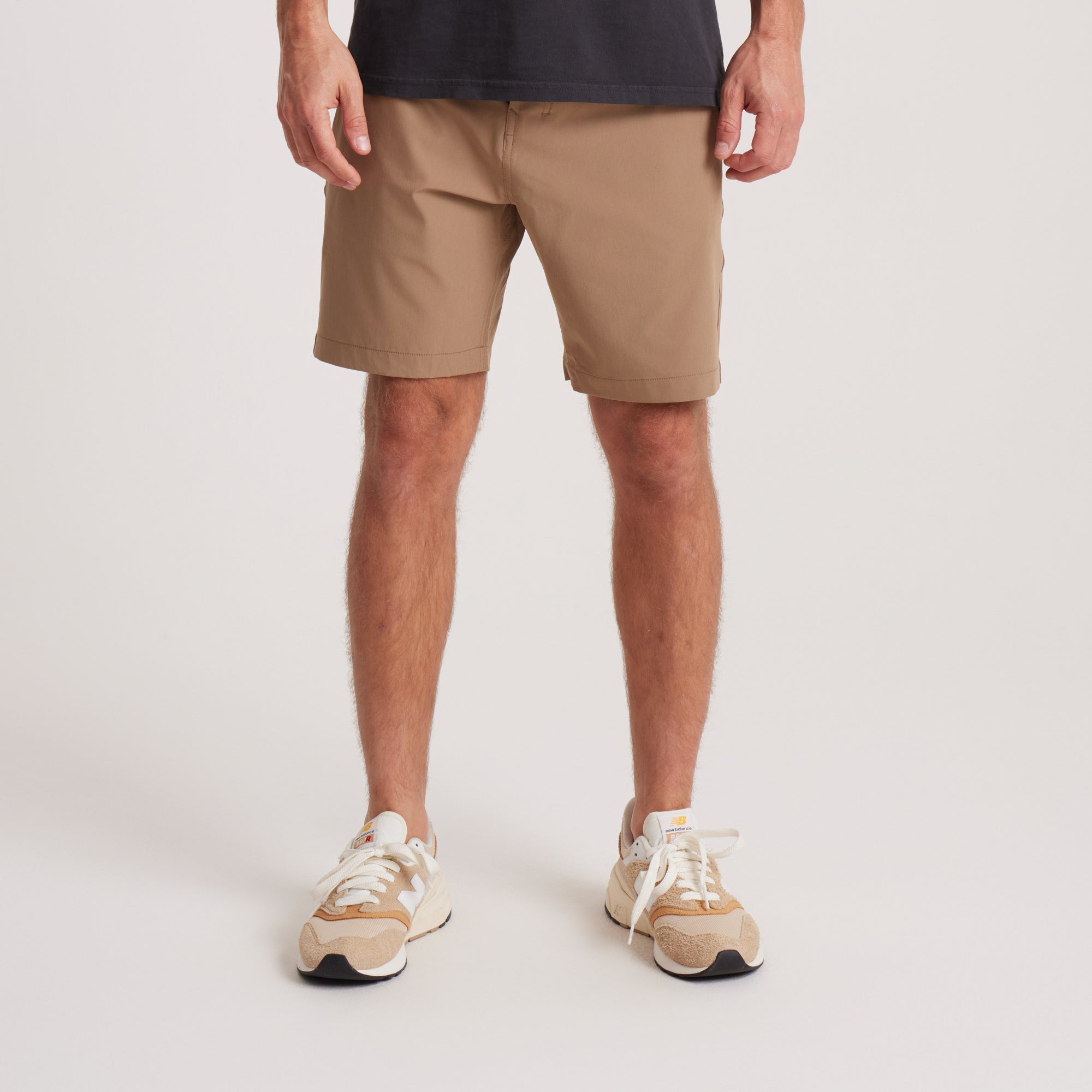 on-model Front view of men's tan hybrid shorts, showcasing a sleek design with functional front pockets and durable construction for everyday wear.