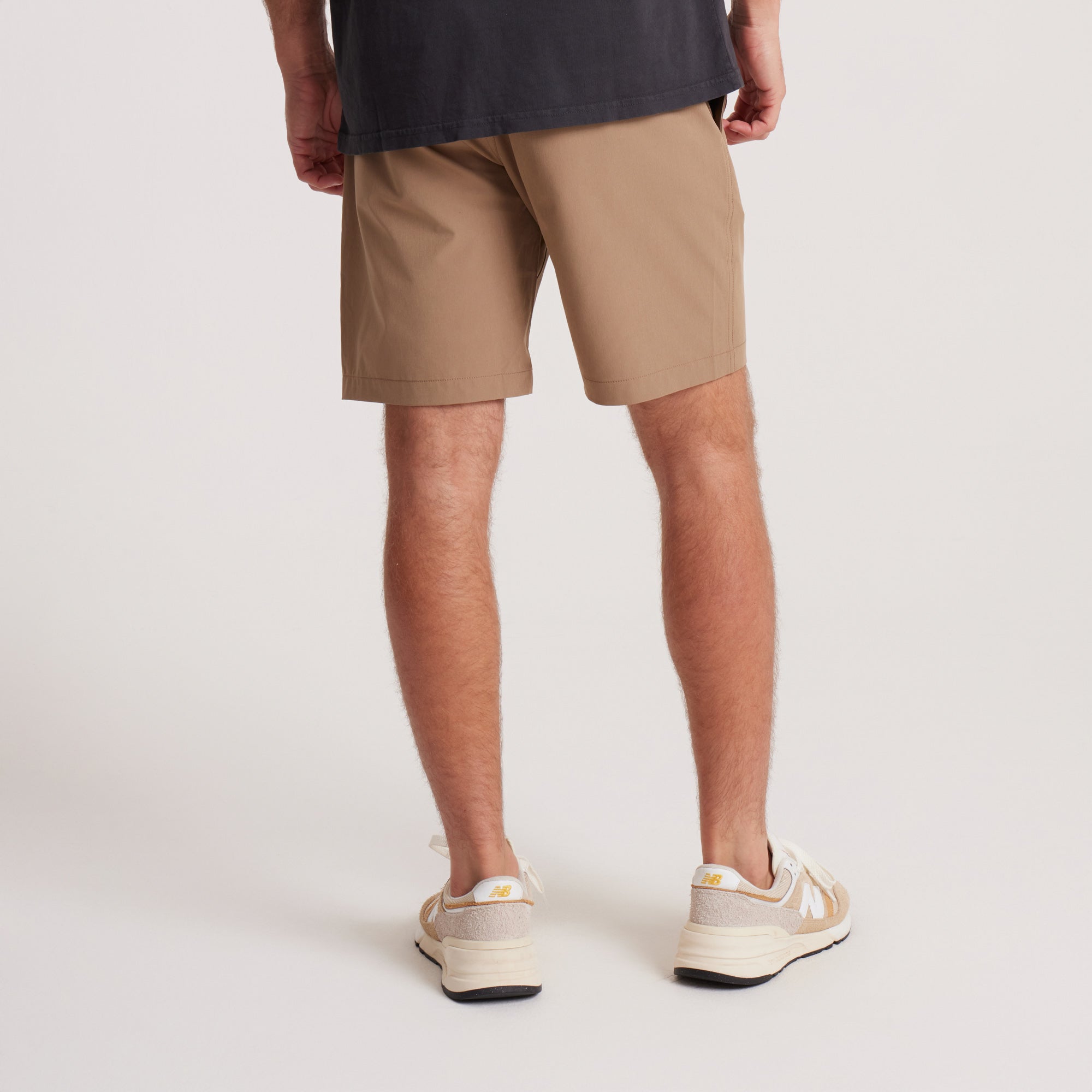 on-model Back view of men's tan hybrid shorts, featuring a relaxed fit and clean seams, perfect for outdoor adventures or casual wear.