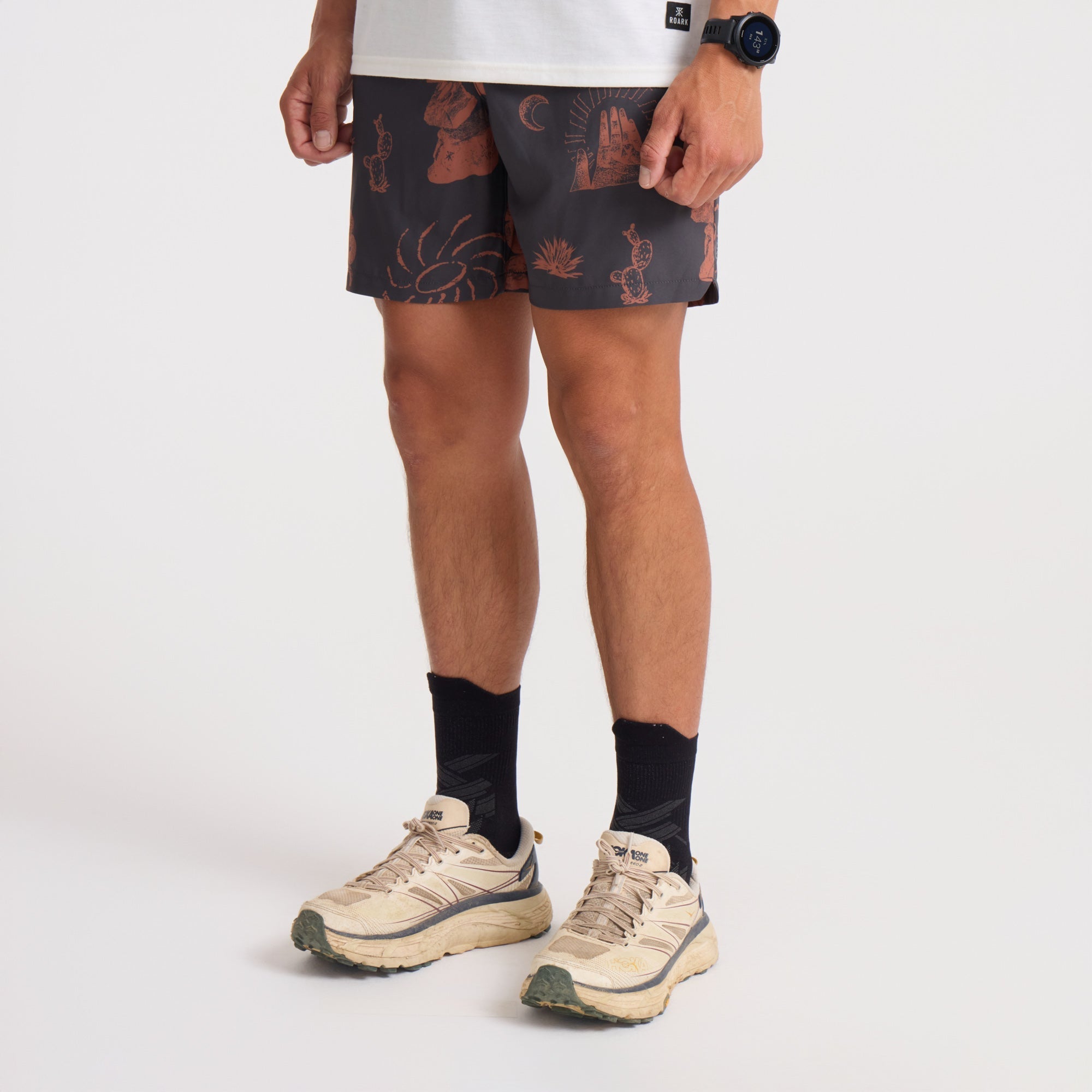 Active man wearing Roark brown and orange boardshorts, perfect for outdoor adventure and travel.