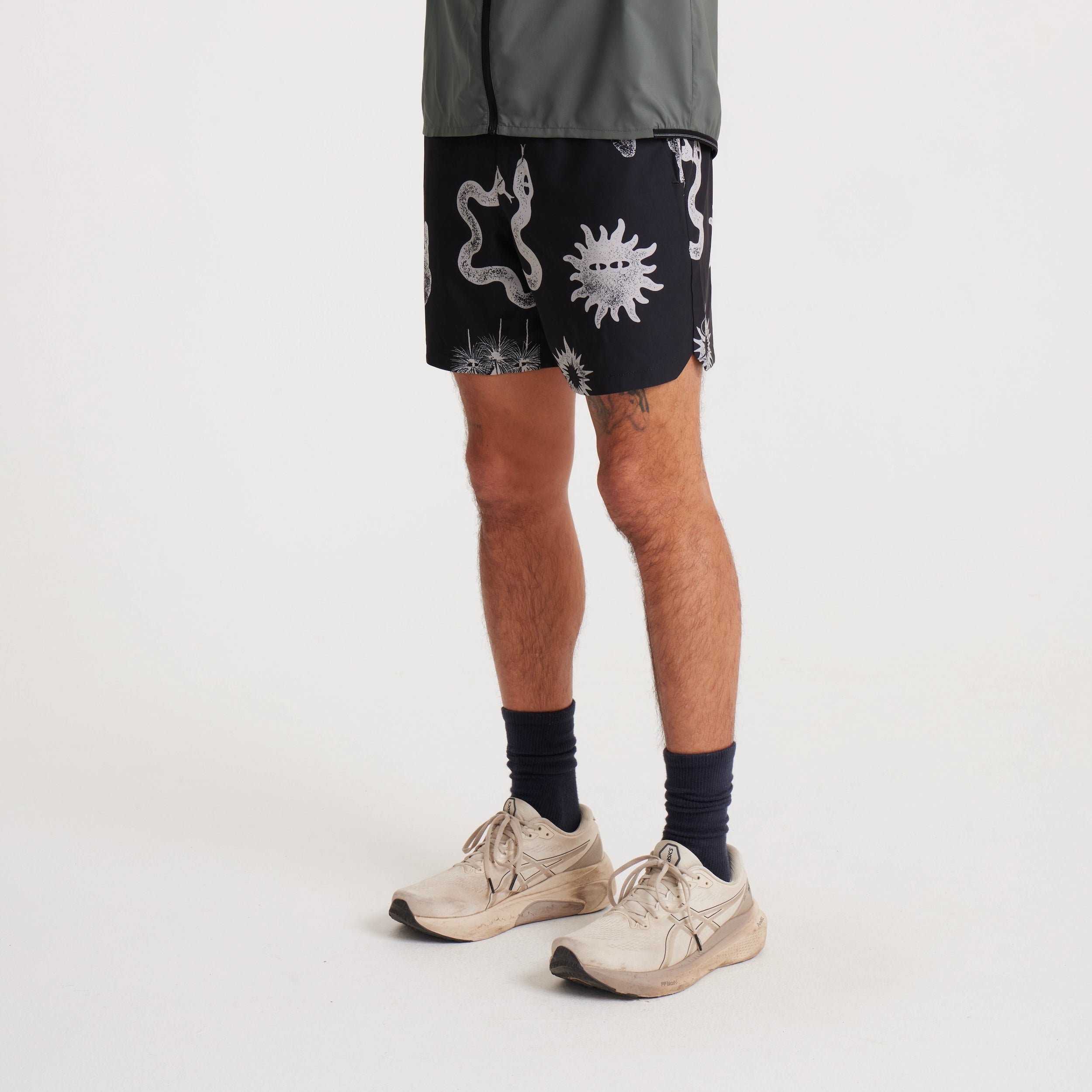 Side view of black swim shorts with unique white graphic prints, highlighting the shorts' modern fit and versatile style for summer activities.