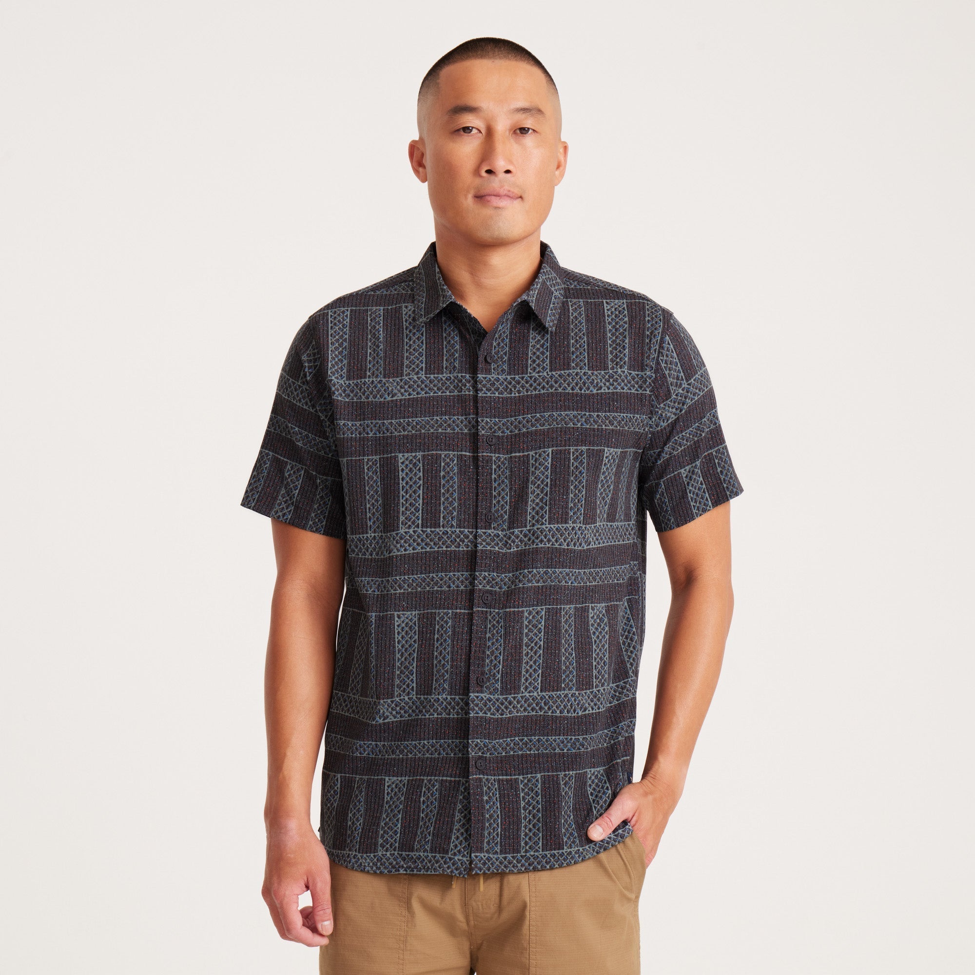 Front view of a short-sleeve button-up shirt with intricate geometric patterns, showcasing modern style.