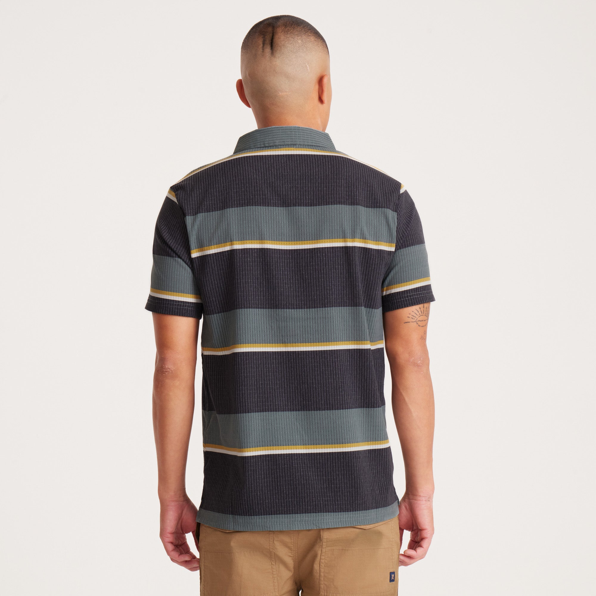 Back view of a men's striped polo shirt in green and black with yellow accents, showcasing a durable and lightweight design for daily wear.