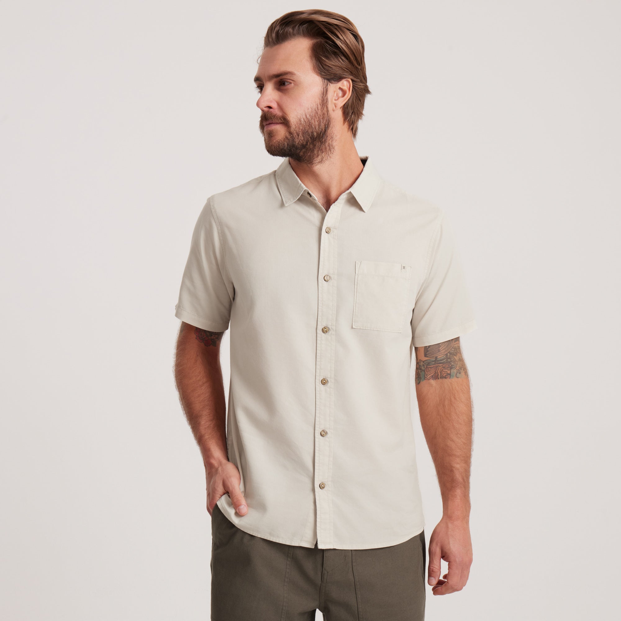 Front view of a men's off-white short-sleeve button-down shirt with a classic collar and chest pocket, a staple for any wardrobe.