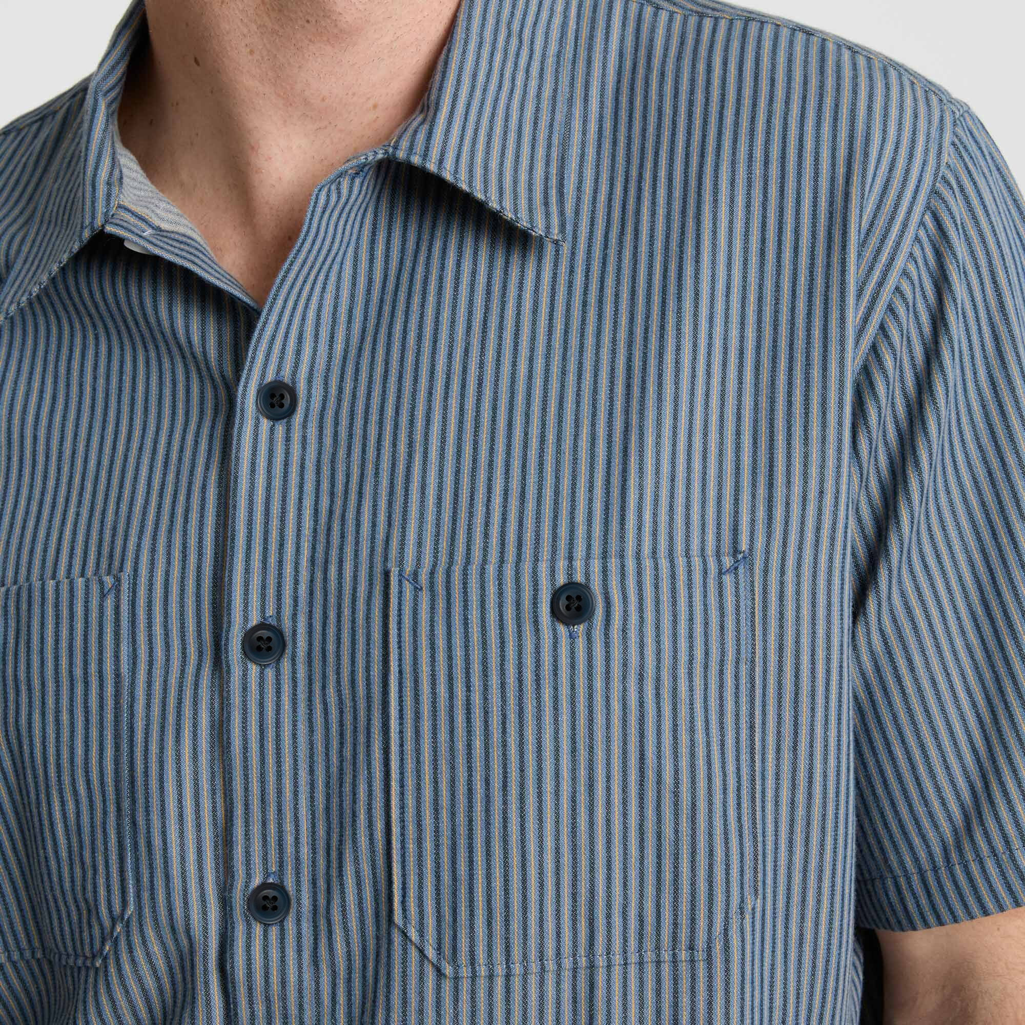 Sturdy denim dress shirt featuring detailed collar and buttons, perfect for adventure and travel.