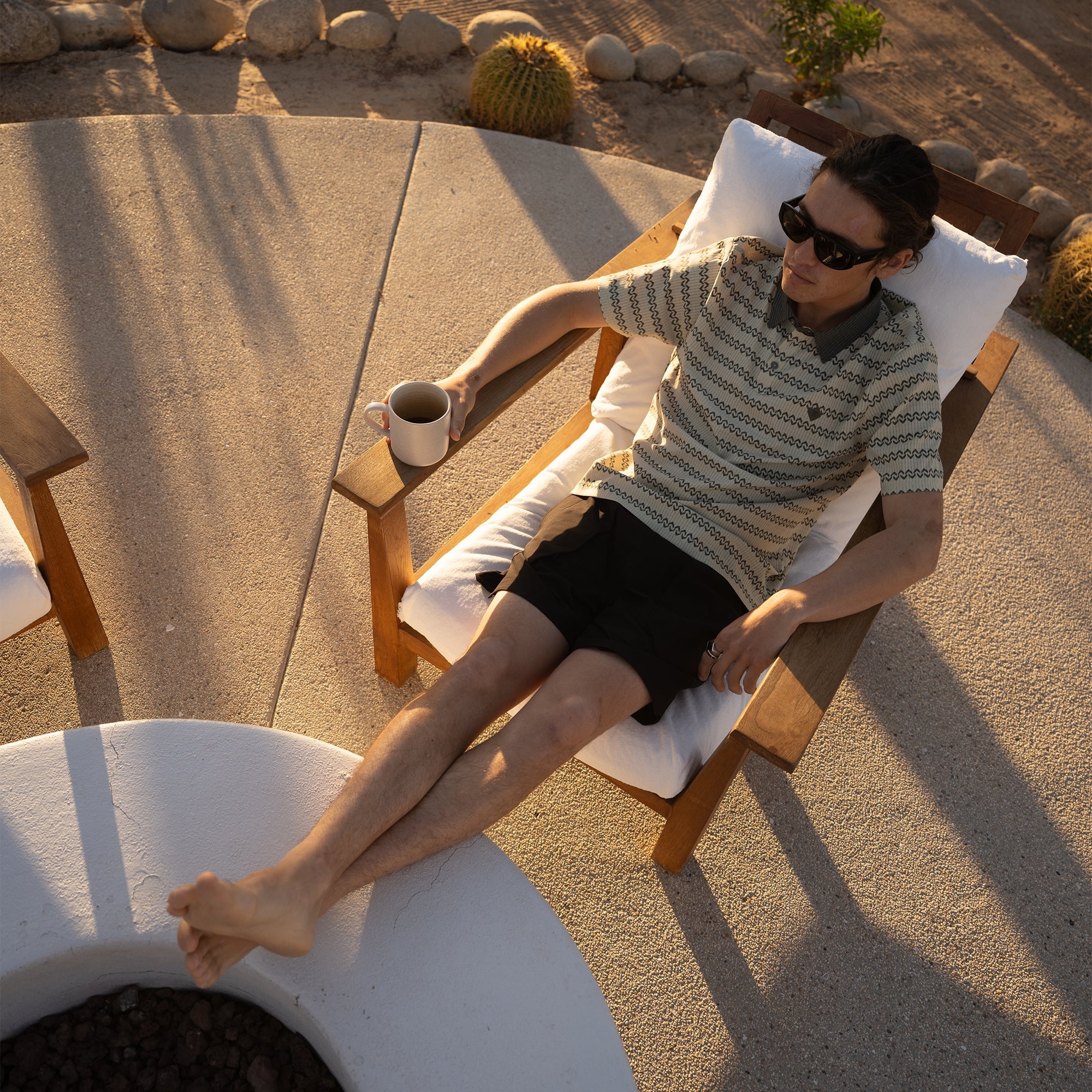 life-style-image Relaxed outdoor setting with comfortable furniture, featuring a person sitting while wearing a hat, embodying Roark's adventure and travel lifestyle.