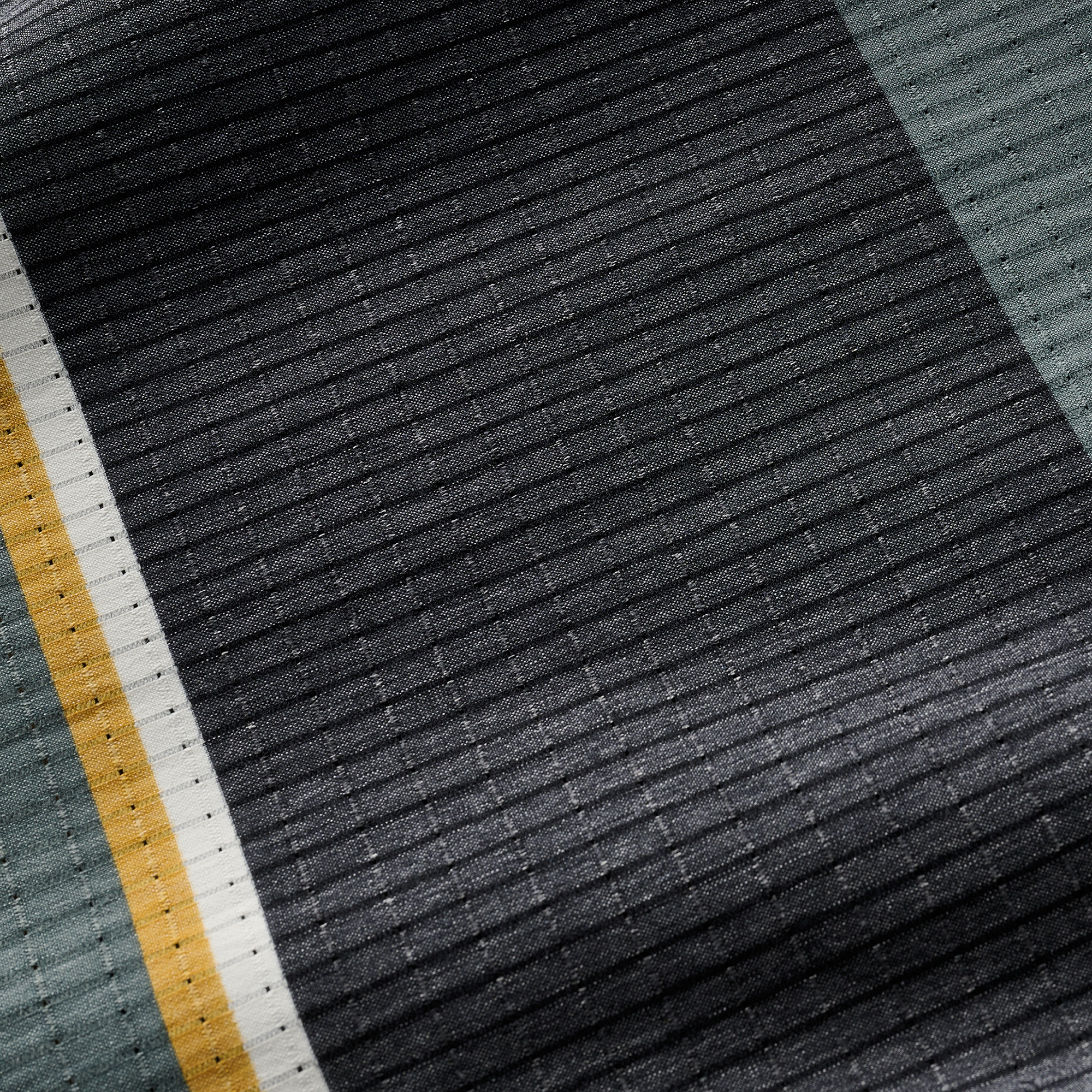 Detailed texture of the striped polo shirt fabric, highlighting its premium lightweight and quick-drying properties.