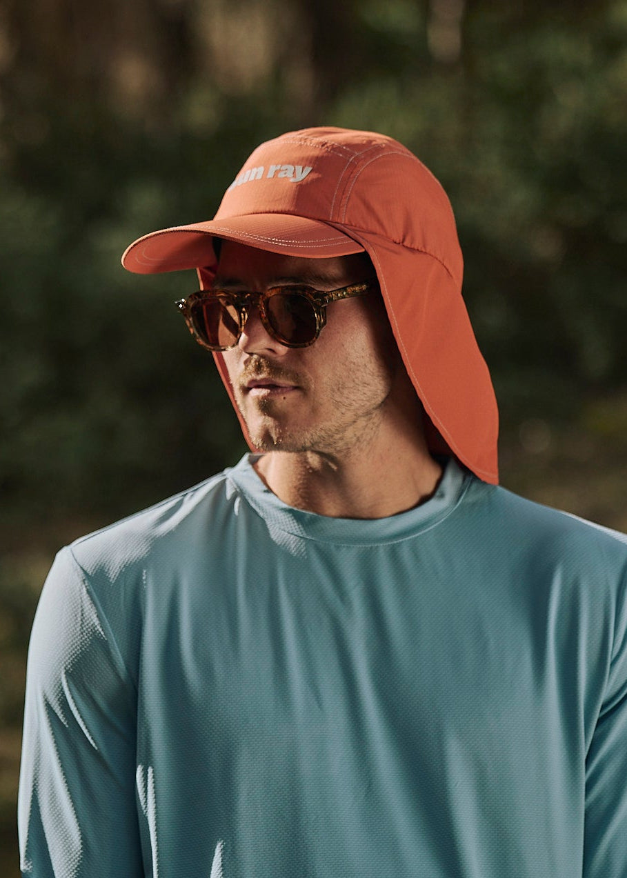 Person wearing an orange UPF50+ sun protection legionnaire hat