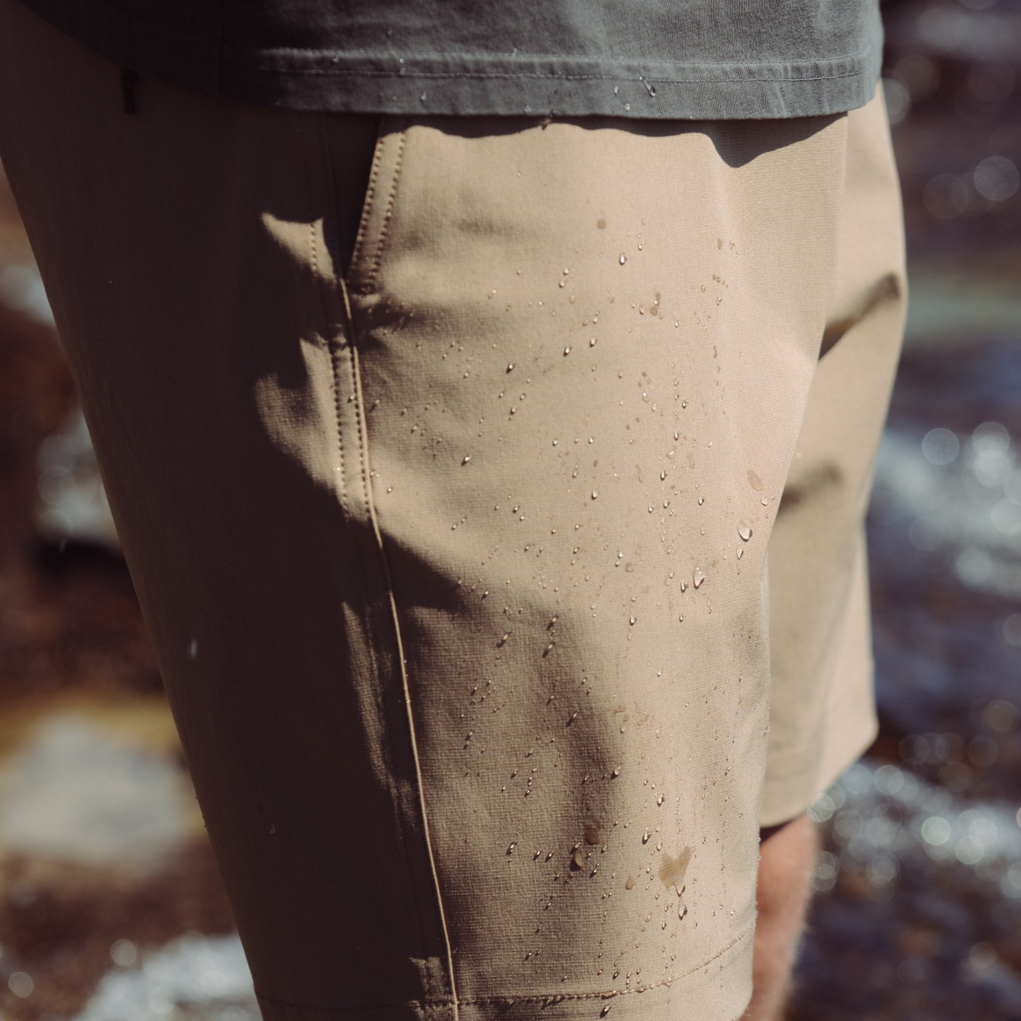 life-style-image Man wearing Hytide Hybrid Shorts from Roark, walking on a scenic dirt road, emphasizing durability and adventure-ready design.