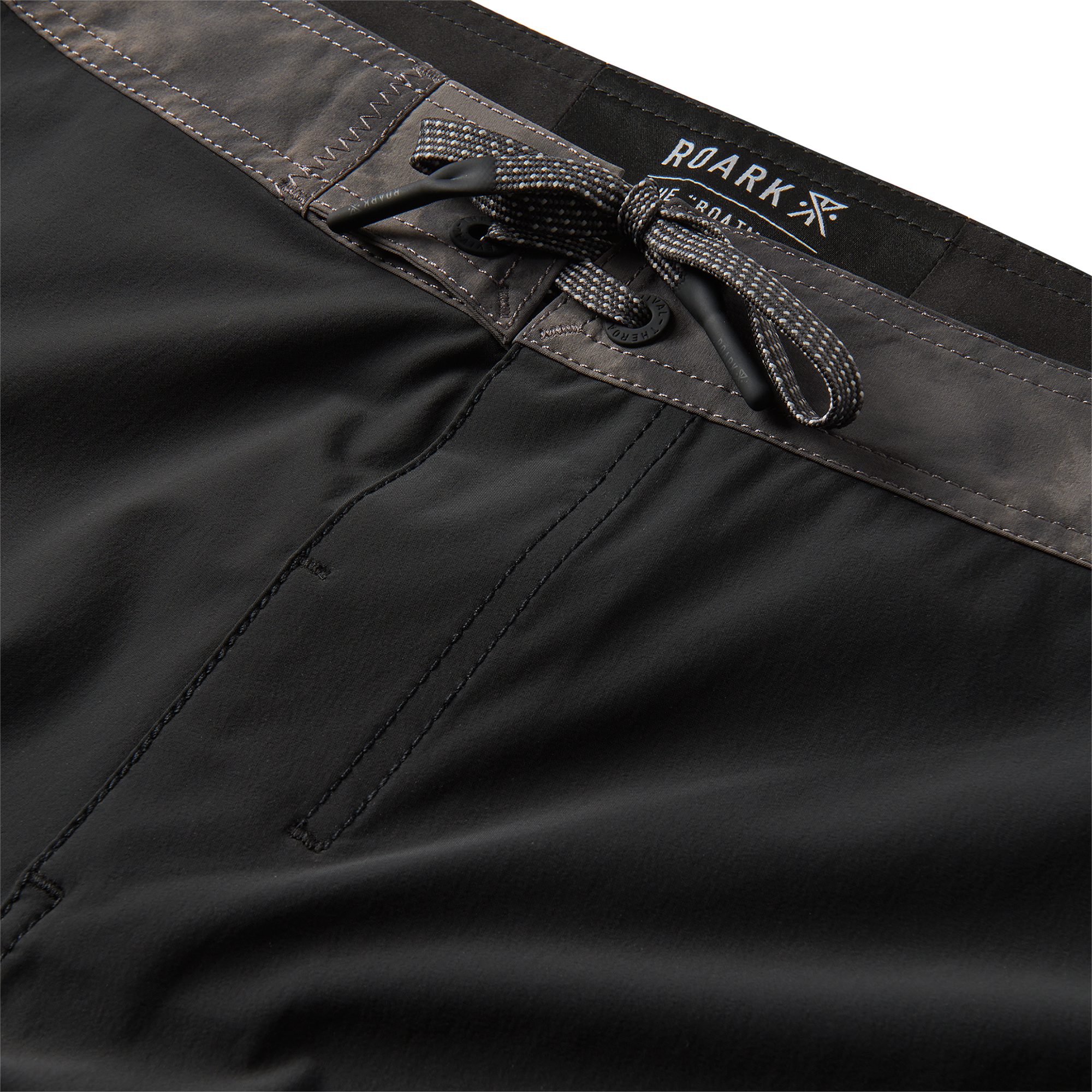 Close-up of the gray waistband with drawstring detail on black boardshorts, offering adjustable comfort and style.