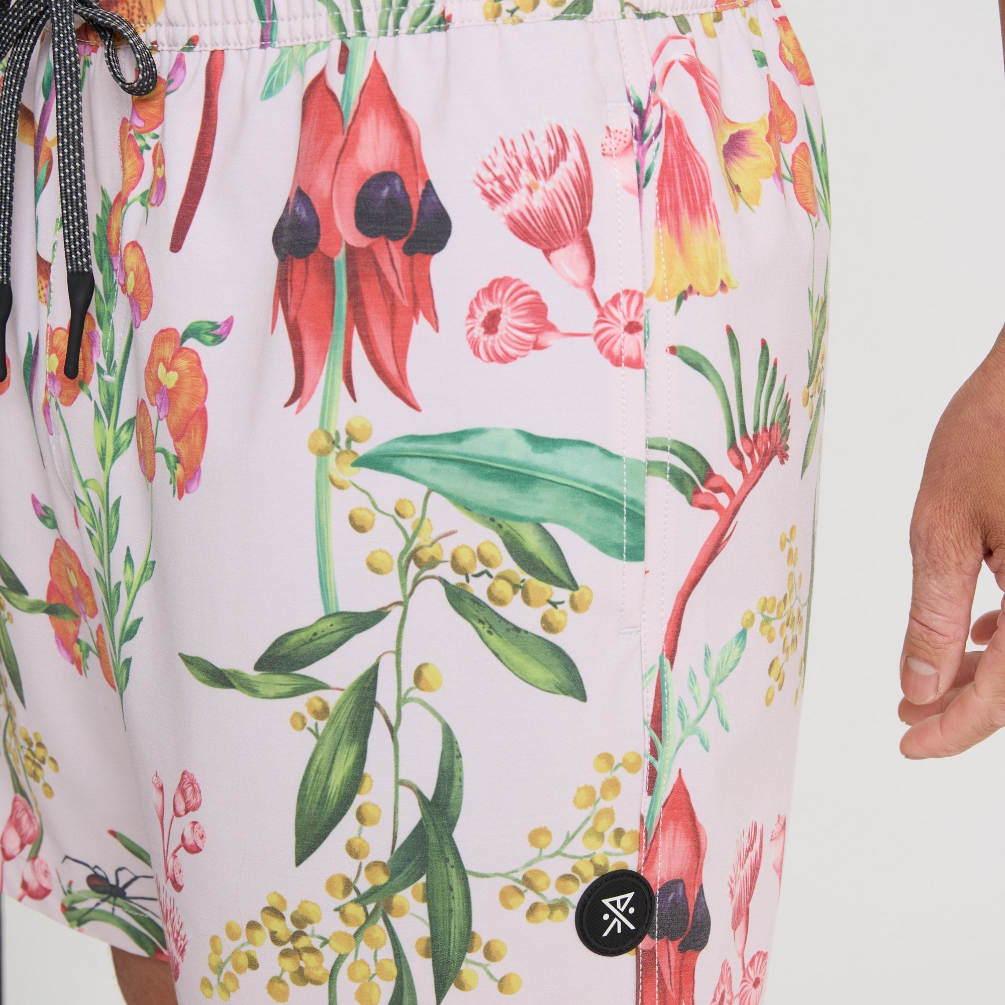 Man wearing pink Roark boardshorts while exploring vibrant outdoor settings, embodying a sense of adventure and travel.