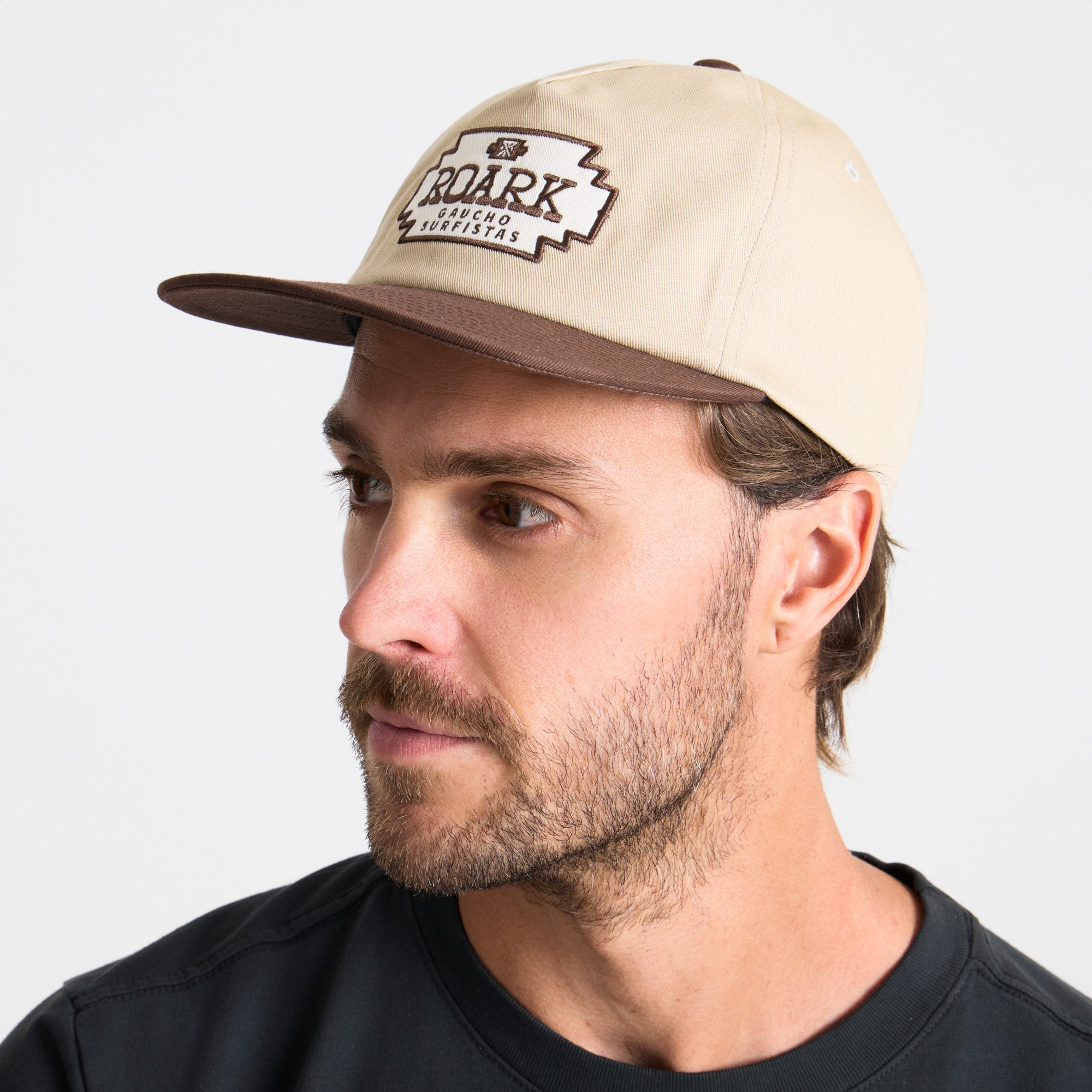 Adventure-ready man with a rugged beard wearing a versatile cap, perfect for outdoor explorations.
