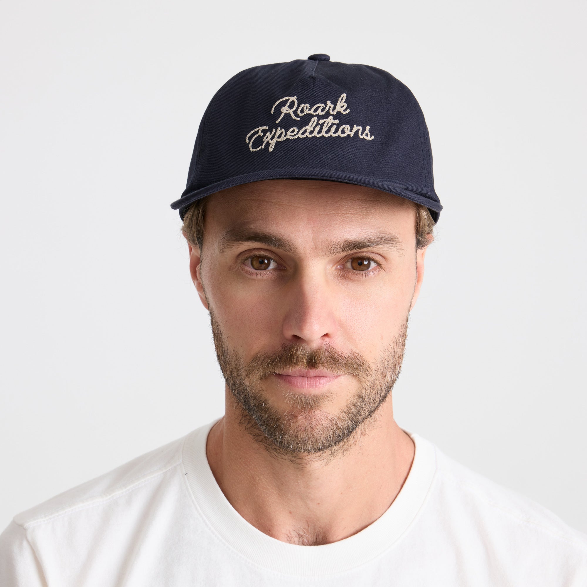 Stylish navy blue Roark baseball cap, perfect for outdoor adventures and travel, displayed against an adventurous backdrop.