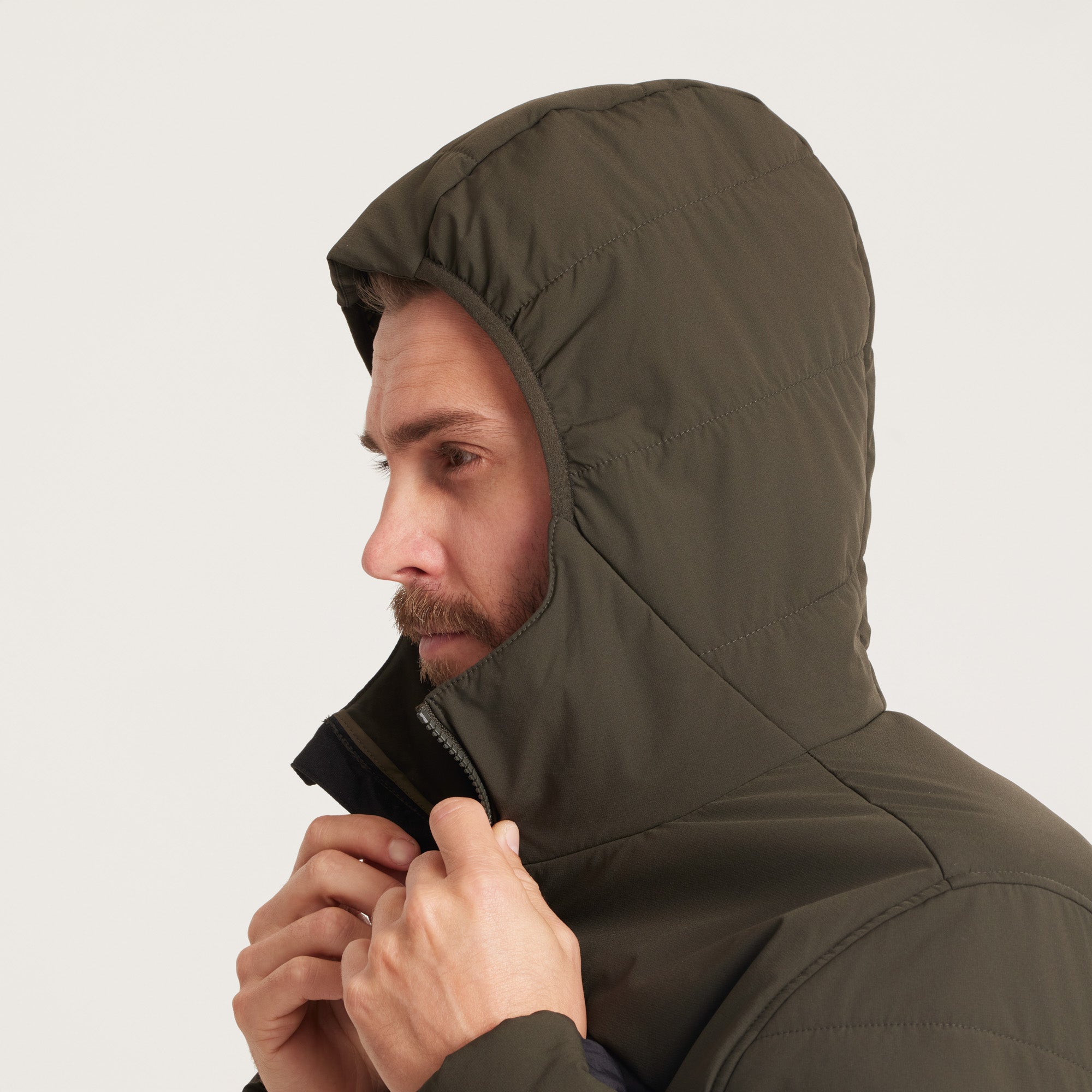 Detailed shot of the hood's edge on a green and black jacket, emphasizing sleek design and weather protection.