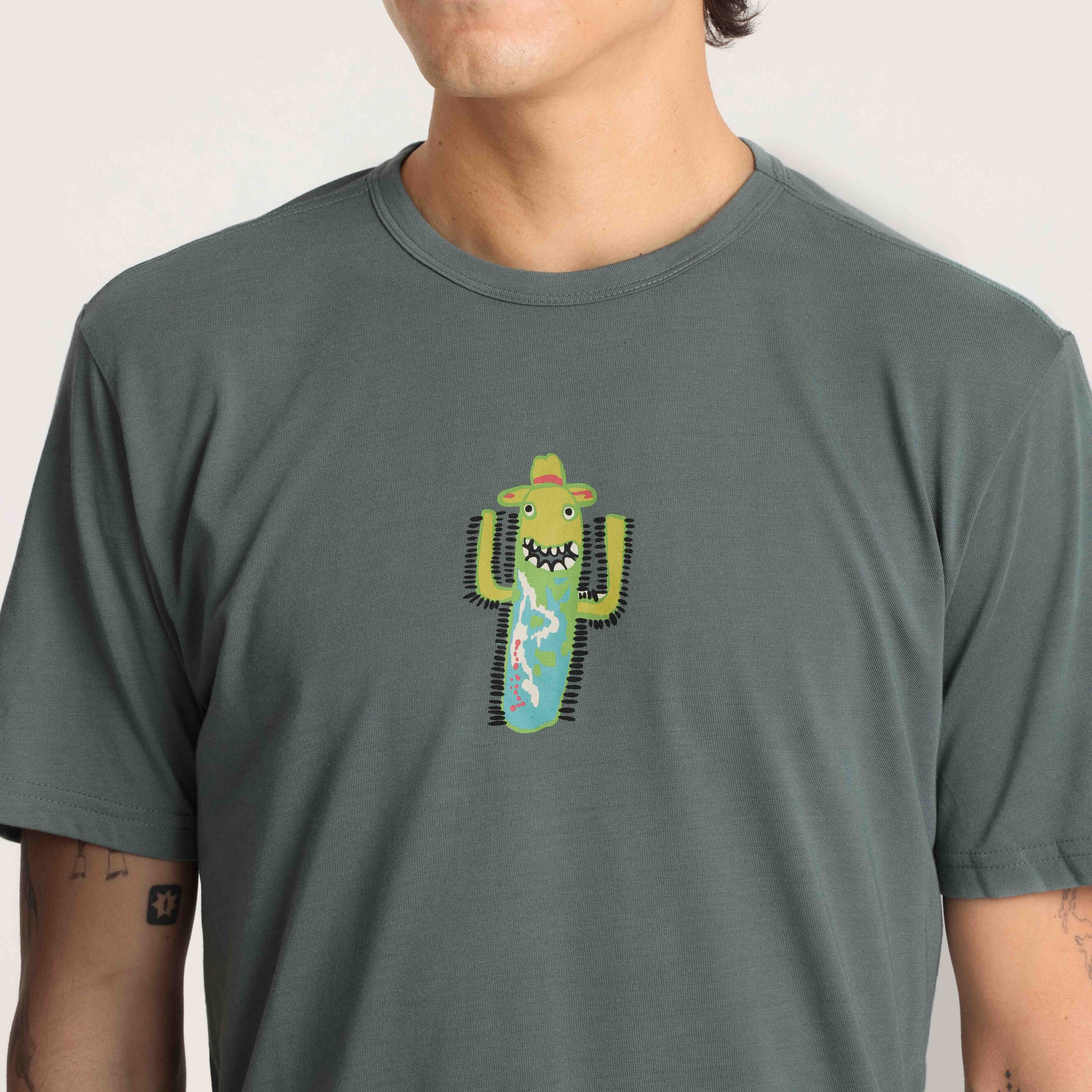 Close-up of a unique cactus design on a green graphic tee, highlighting the playful and creative artwork.