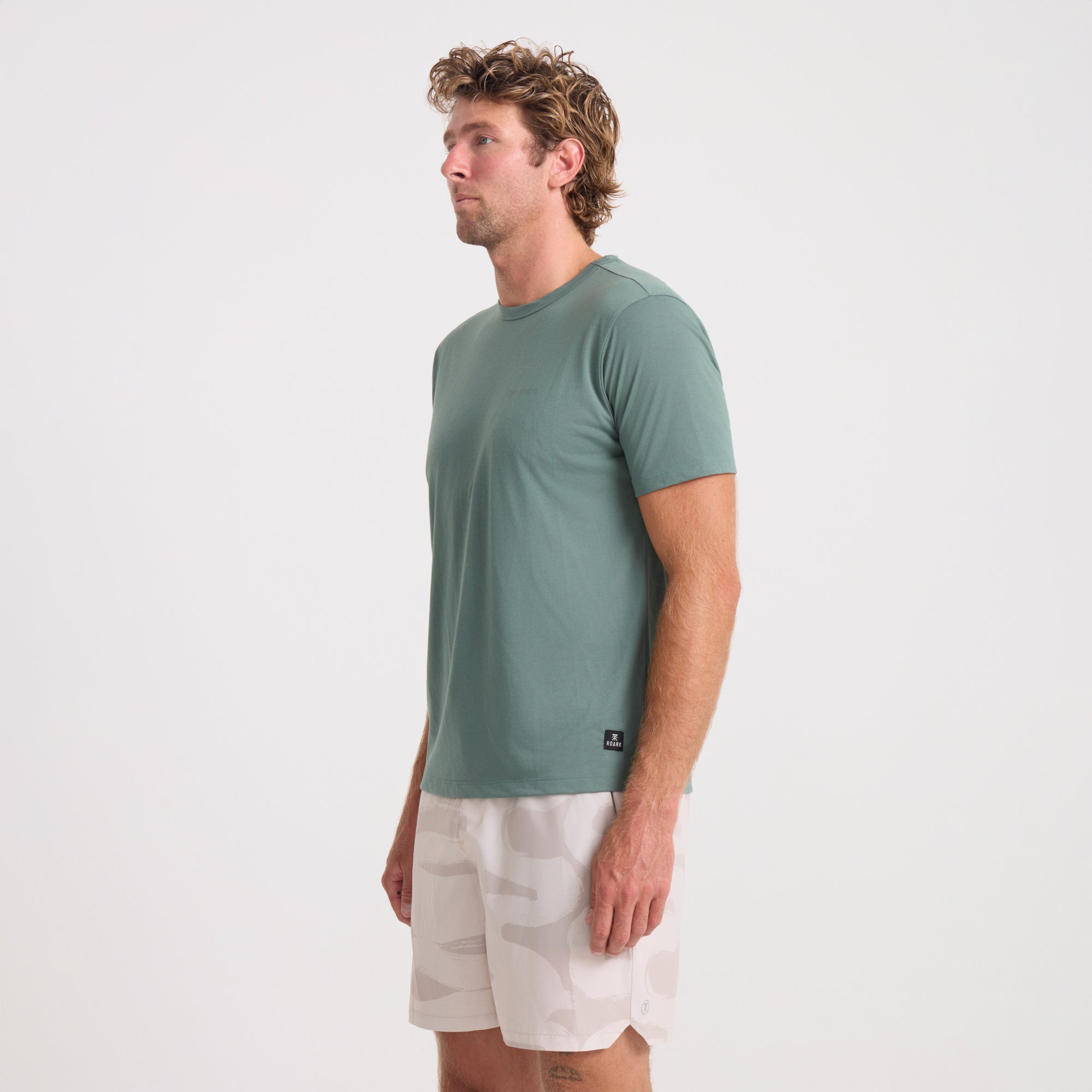 Active male adventurer wearing a versatile Roark shirt, focusing on the shirt's elbow, waist, and shoulder details, ideal for outdoor activities.