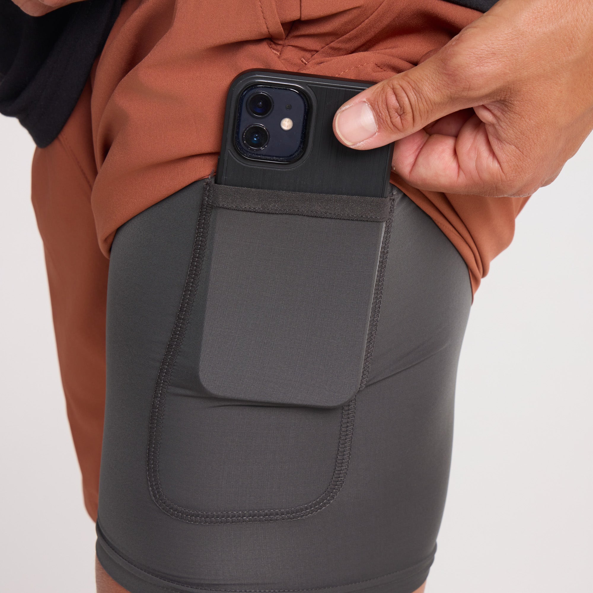 Adventurer using a mobile phone to navigate the terrain while a calf grazes nearby, blending technology with rural exploration.