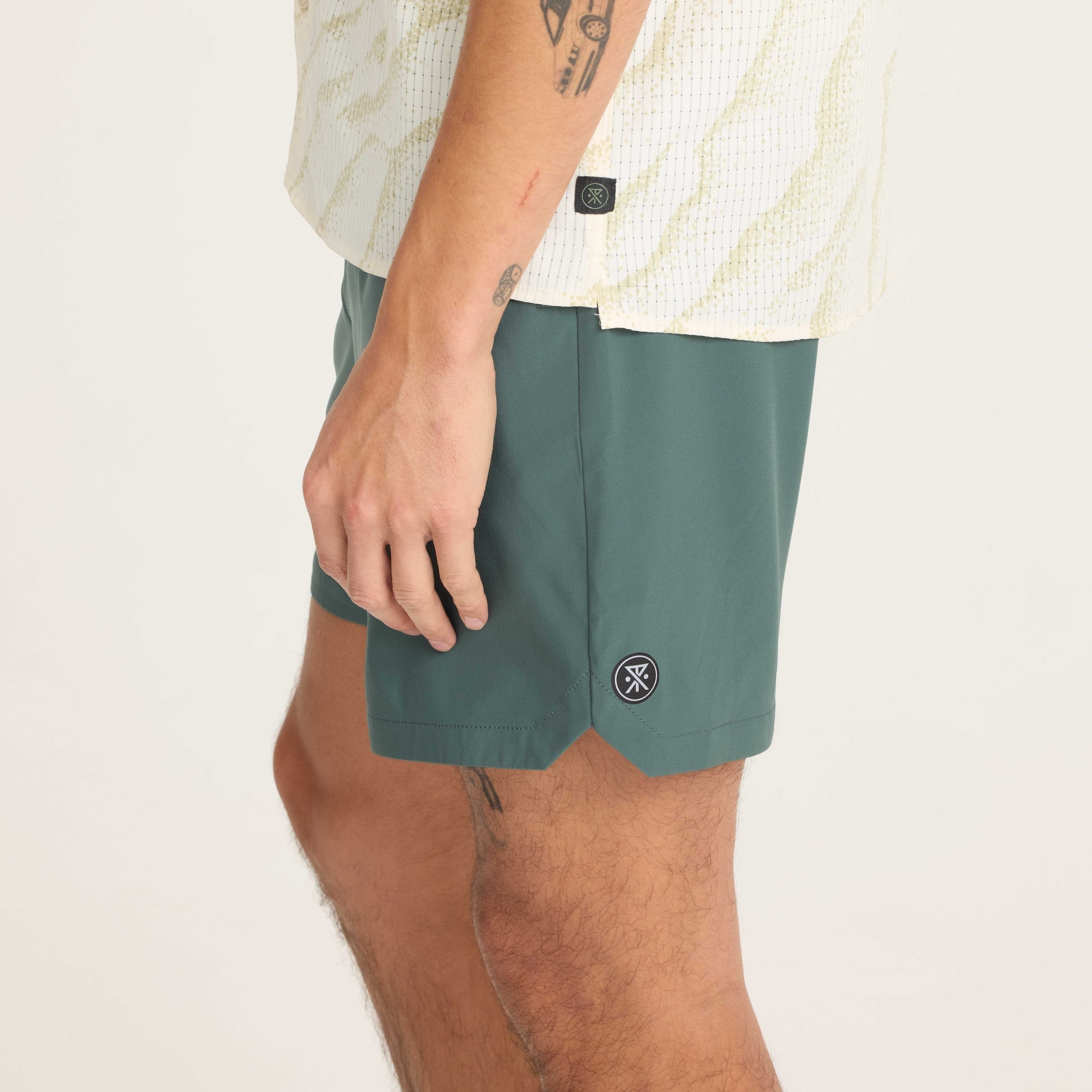 Side profile of green men's shorts showcasing durable material and a comfortable fit for versatile use.