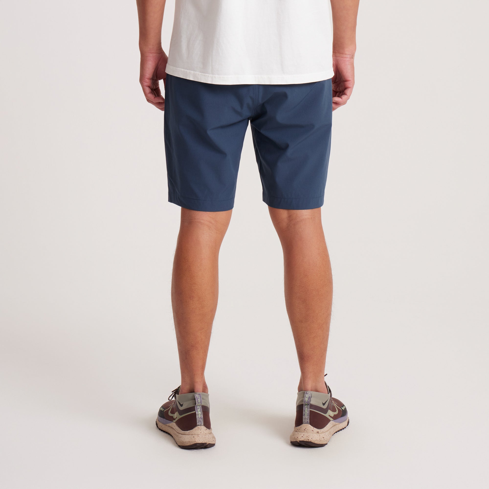 Back view of navy hybrid shorts highlighting zippered pockets and durable fabric for style and practicality.