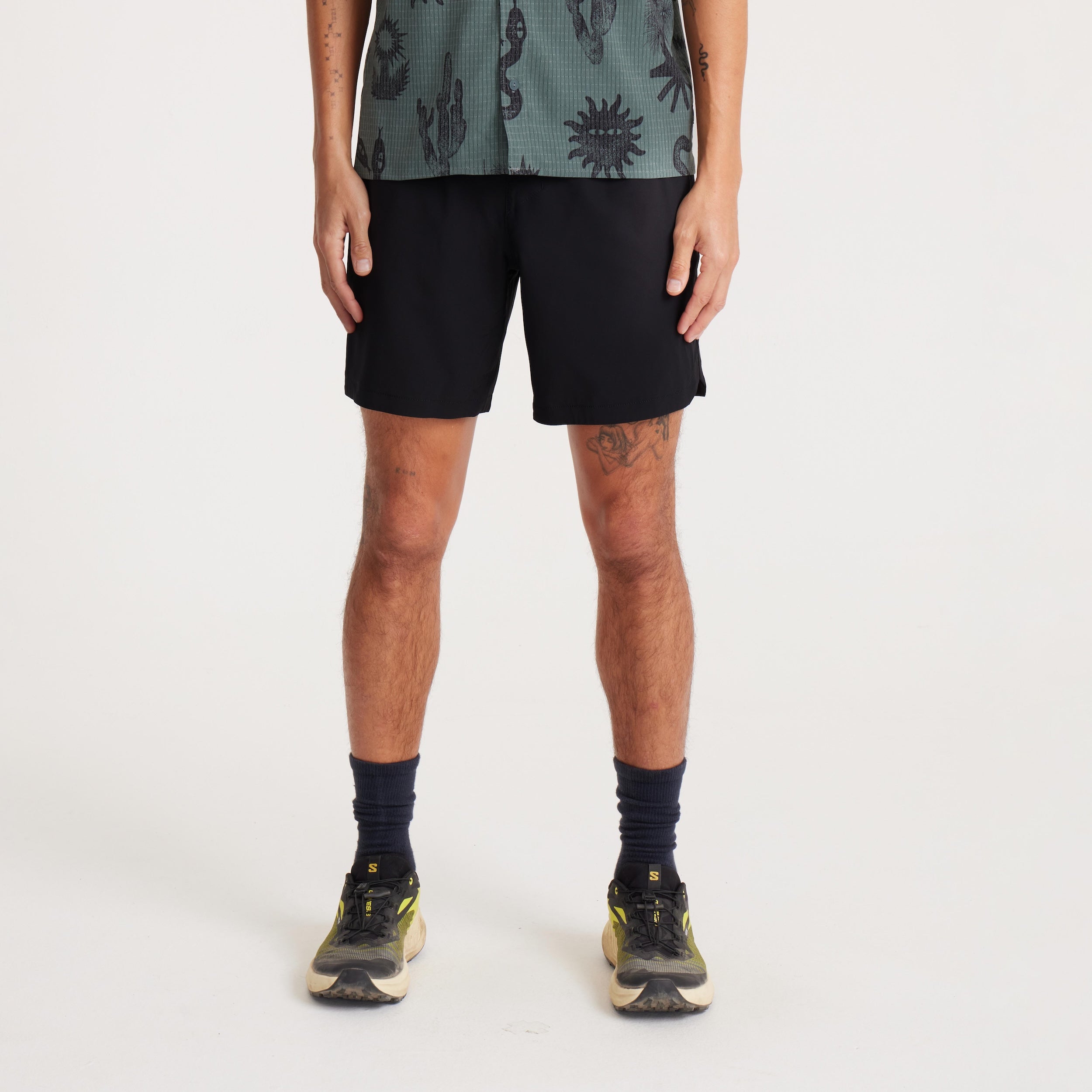 Model wearing black Serrano athletic shorts, front view, showcasing the versatile design perfect for trail running, workouts, or casual activities.