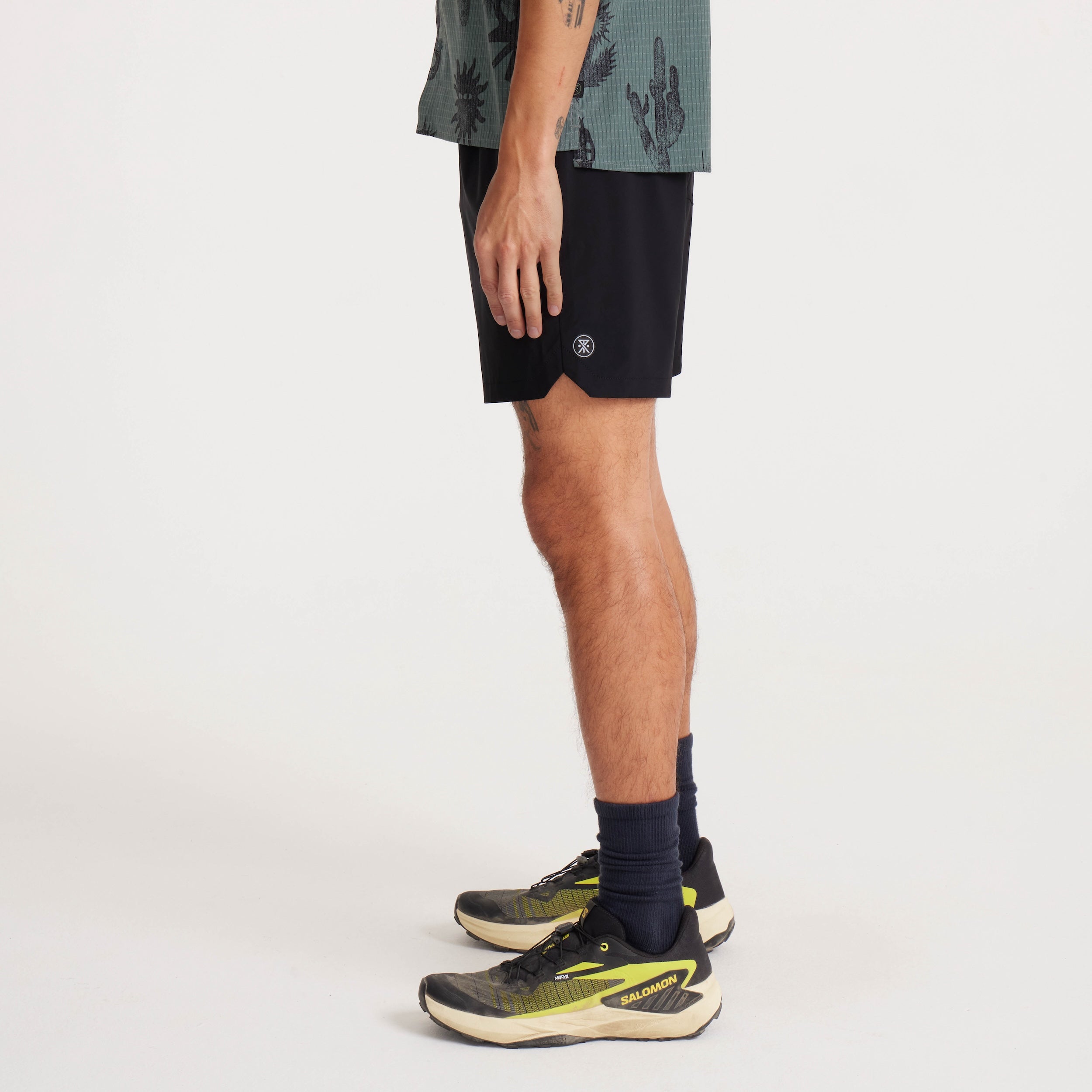 Side profile of model wearing black Serrano shorts, emphasizing the lightweight design and iconic Roark logo detail.