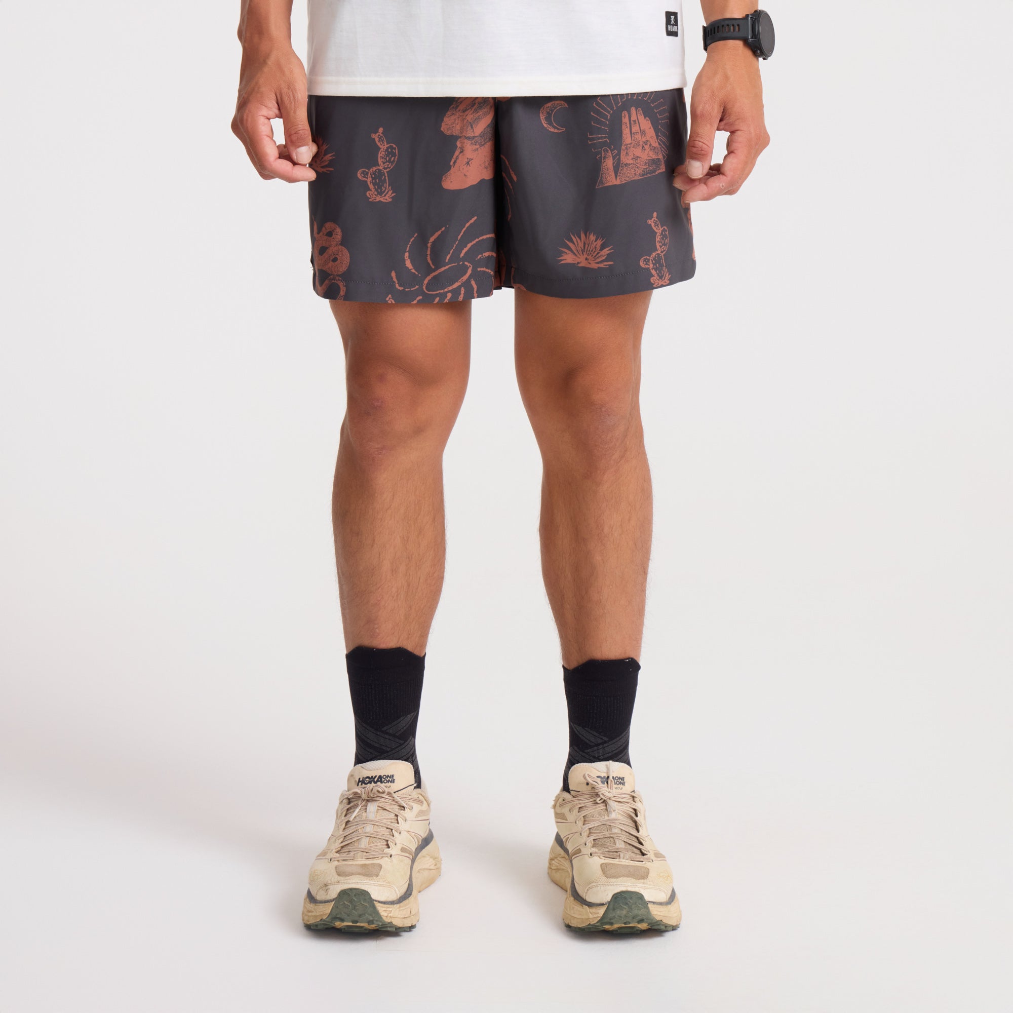 Man in brown and orange boardshorts, embodying the adventure and outdoor spirit of Roark, actively engaged in an outdoor setting.