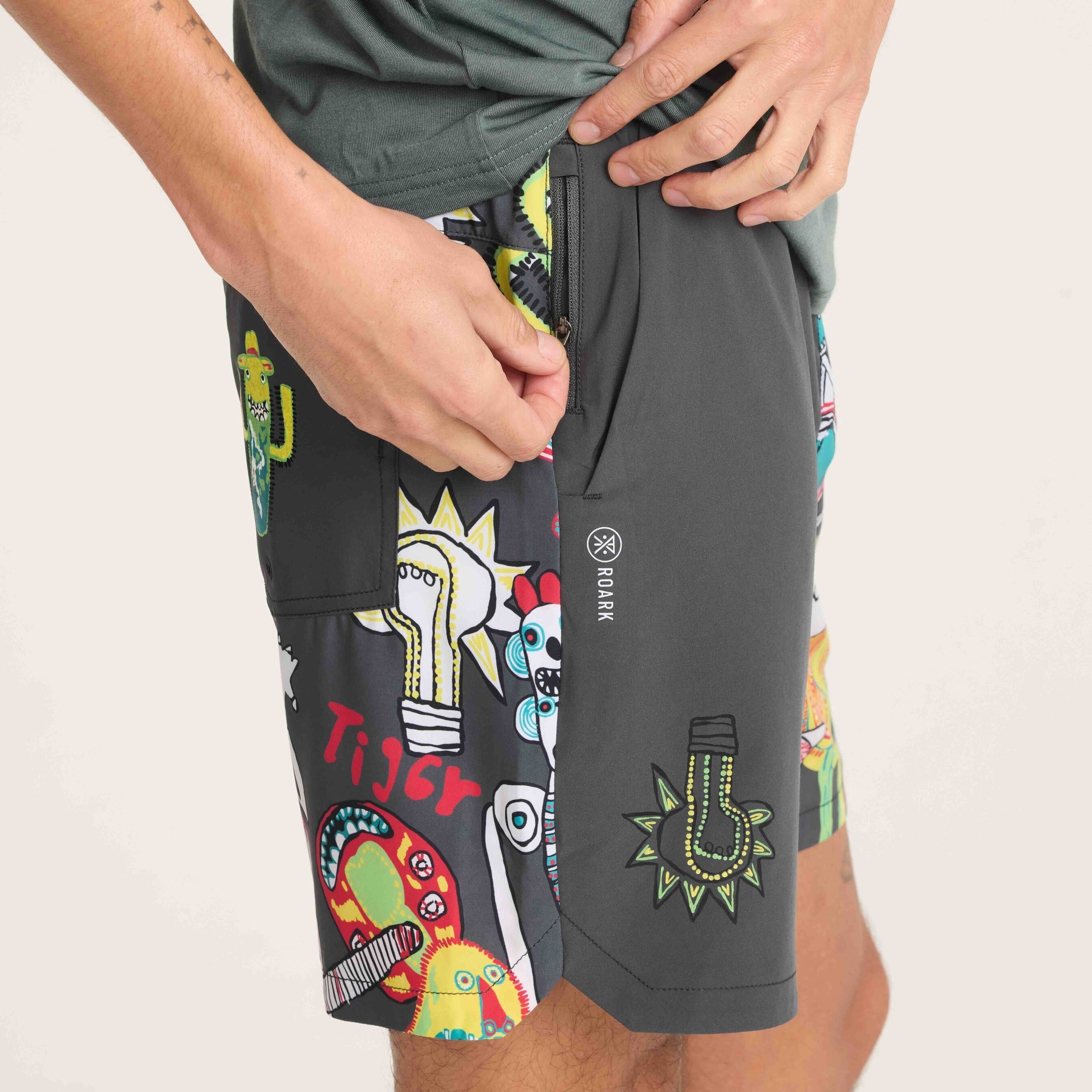 Close-up of men's swim shorts showcasing a zippered pocket and vibrant graphic design with bold and colorful details, perfect for casual wear.