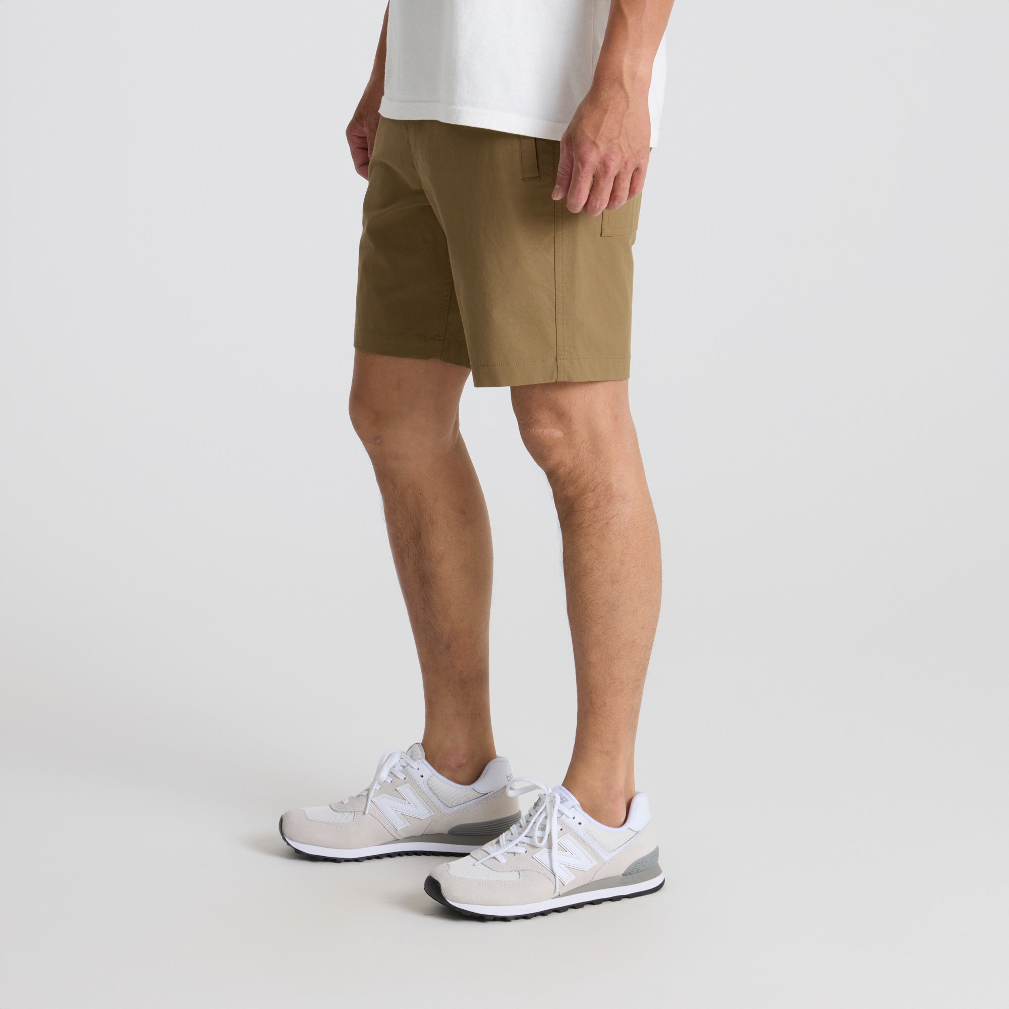 Man exploring scenic outdoor trails, wearing Roark's versatile active shorts paired with walking shoes, emphasizing comfort and durability in adventure gear.