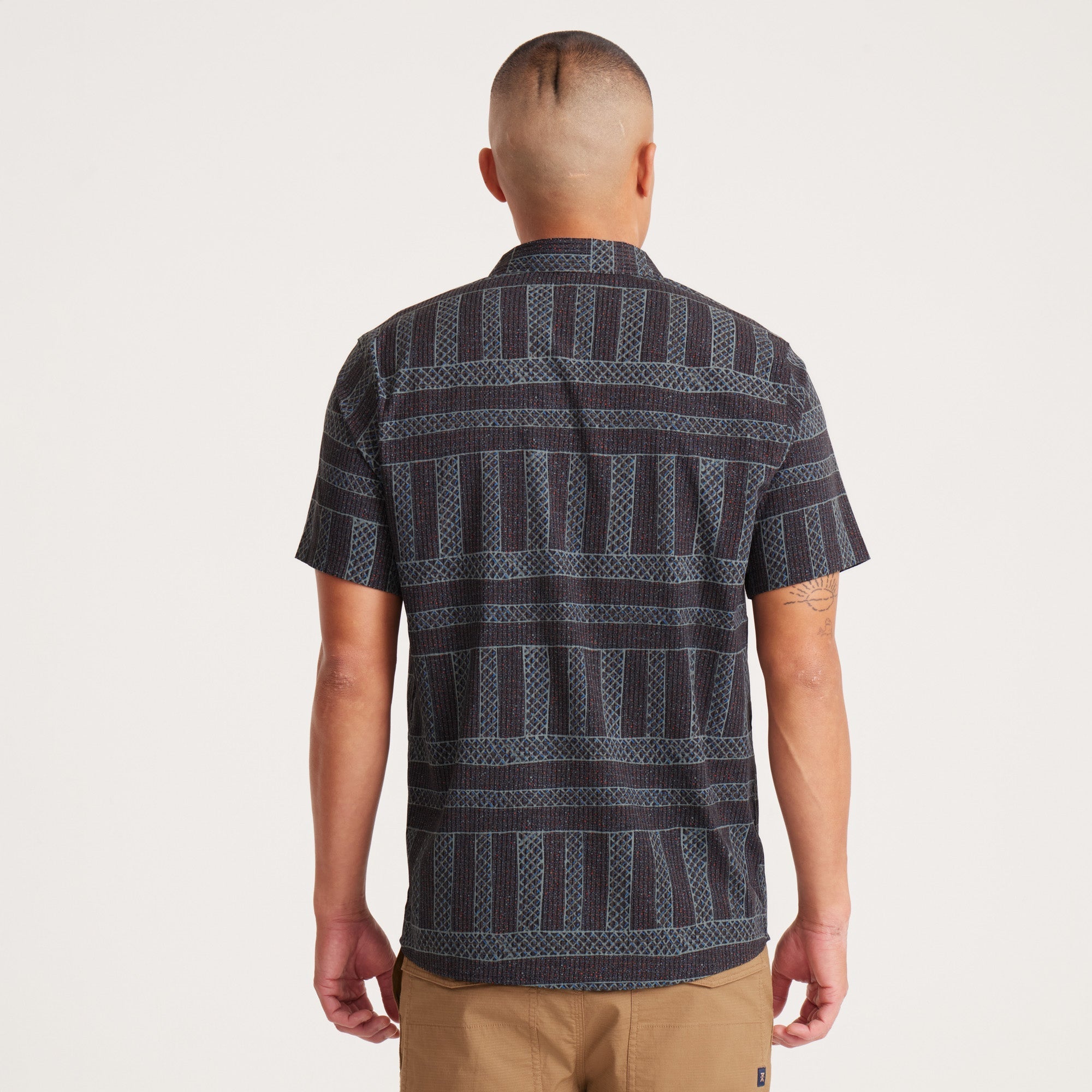 Back view of a model in a geometric-patterned shirt, emphasizing the fit and pattern continuity.
