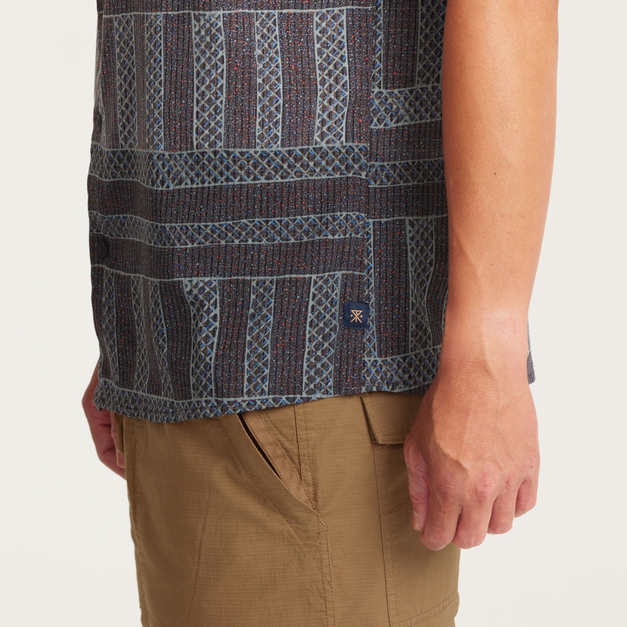 Model showcasing the geometric-patterned shirt in a relaxed pose, ideal for casual fashion inspiration.
