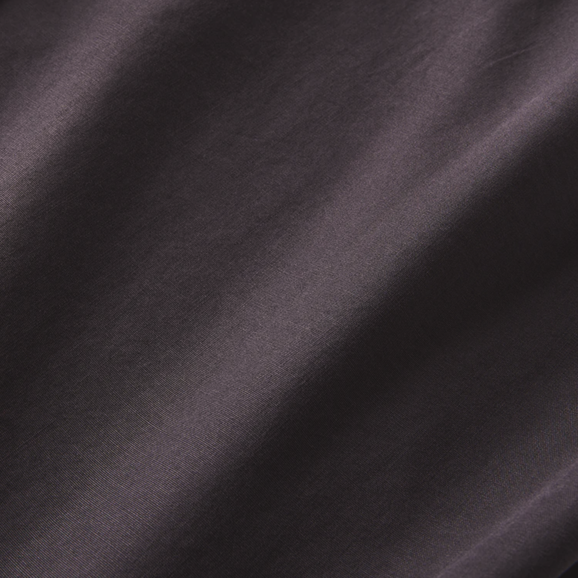 Textured fabric of the black button-up shirt, emphasizing its smooth finish and premium material quality.