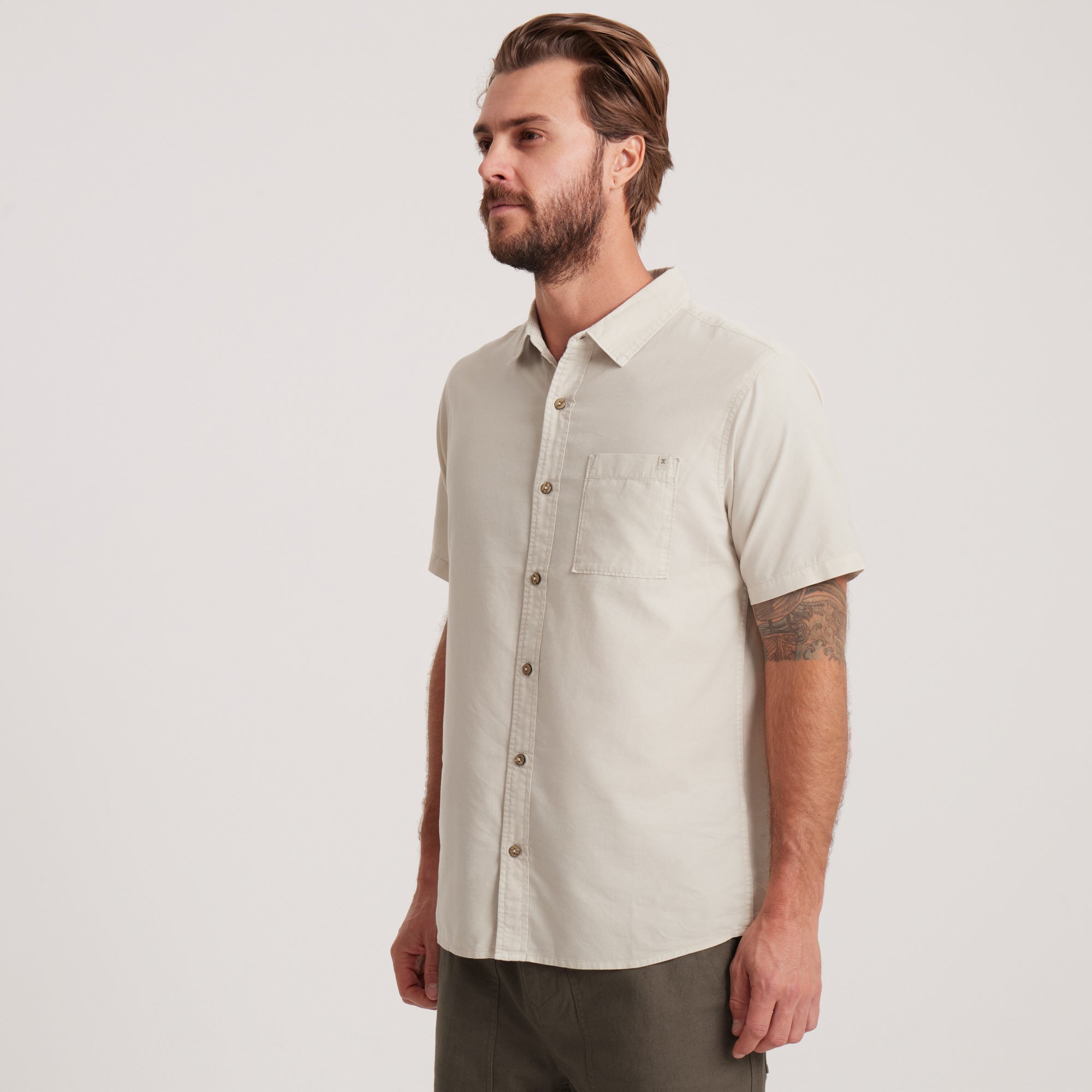 Angled side view of an off-white short-sleeve button-down shirt for men, ideal for warm-weather outings and smart-casual occasions.
