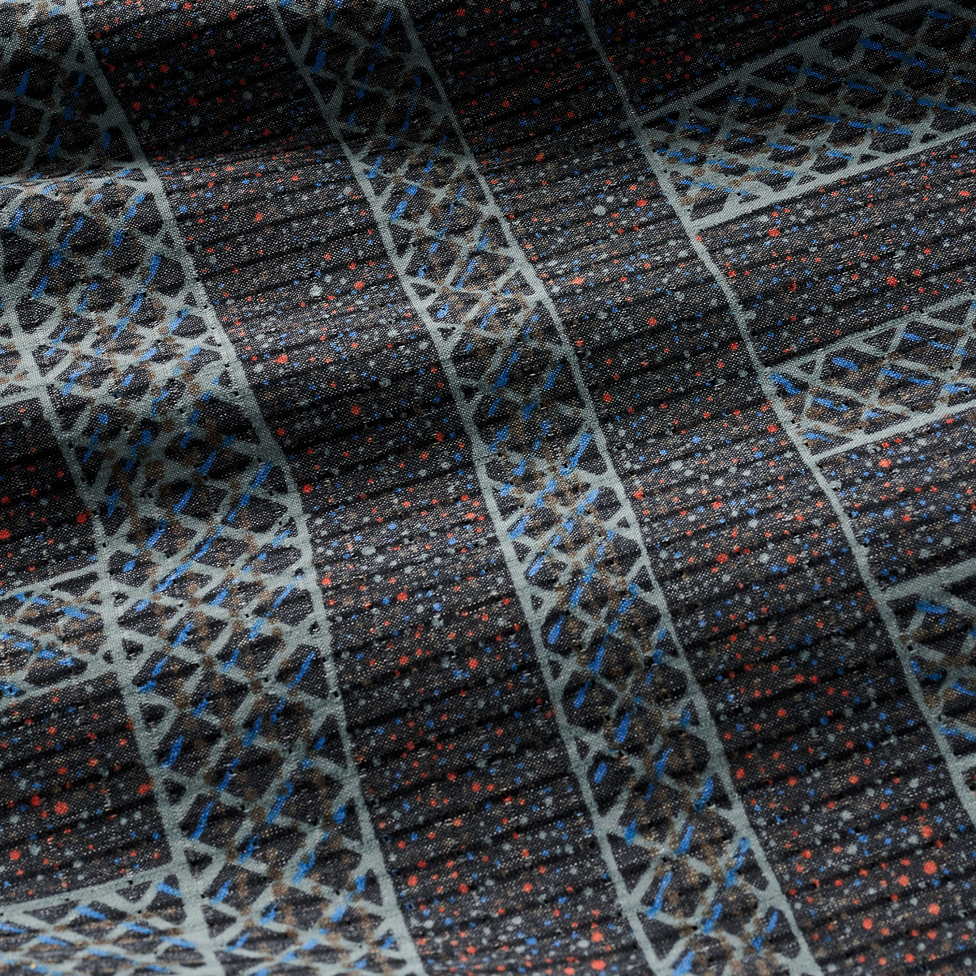 Fabric detail showcasing intricate geometric patterns with dotted accents on a textured surface.
