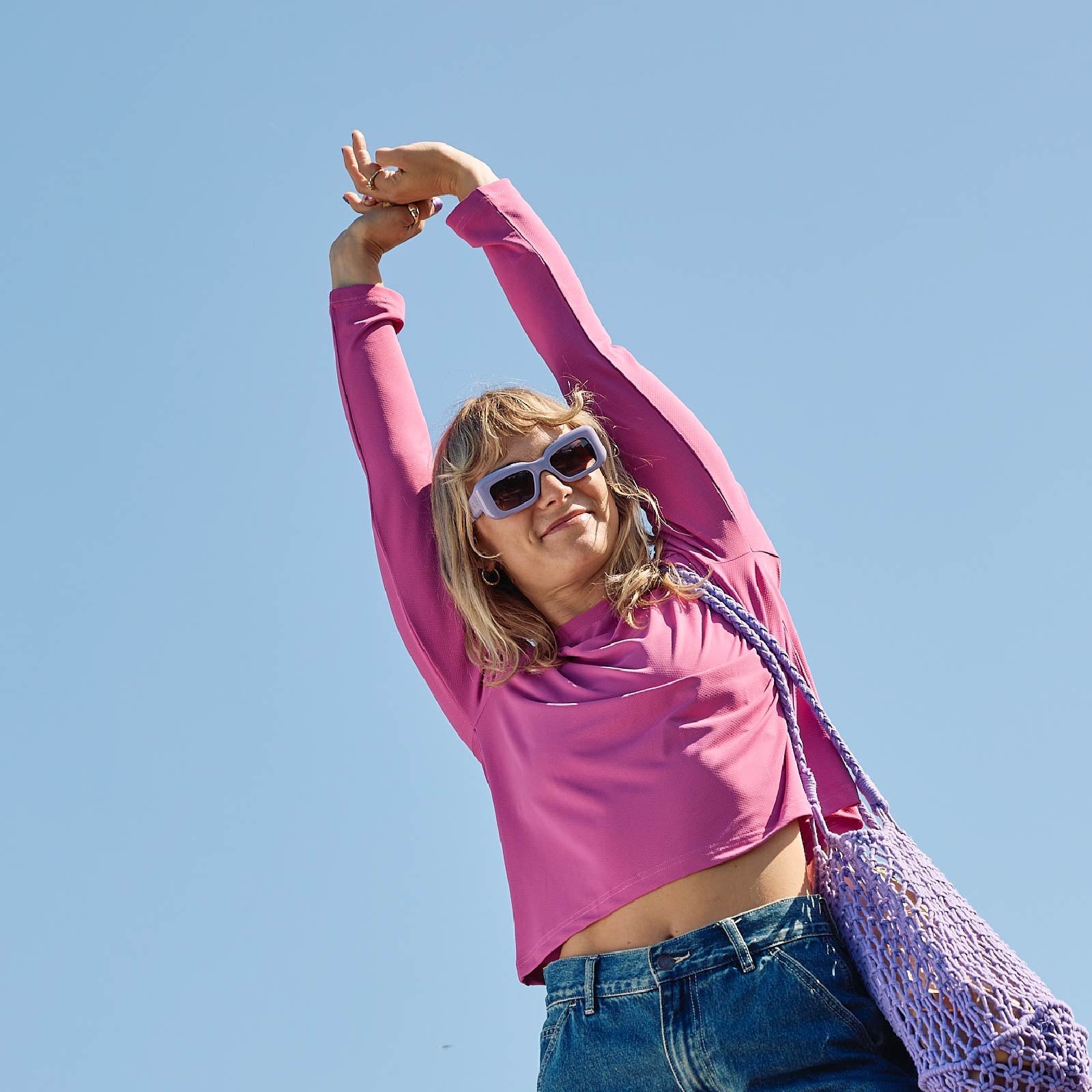 A sun smart woman wears the Sun Ray UPF50+ Sun Protection Clothing All G Long Sleeve Tee fuchsia boxy fit and Shade Cap in Australia