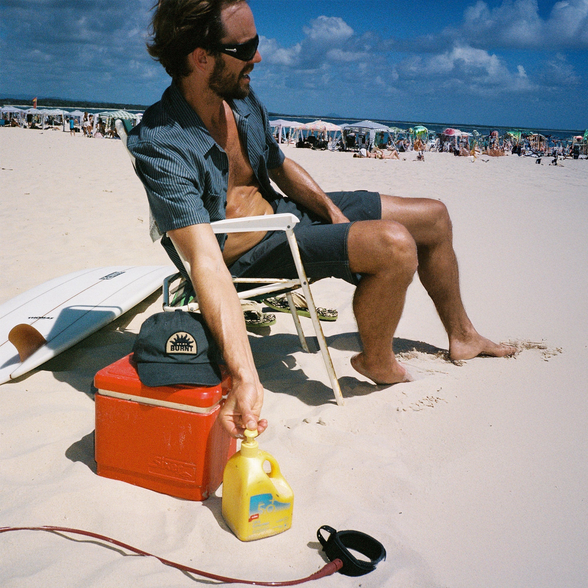 sunseeker on the beach wearing a rad blue stripe shirt 
